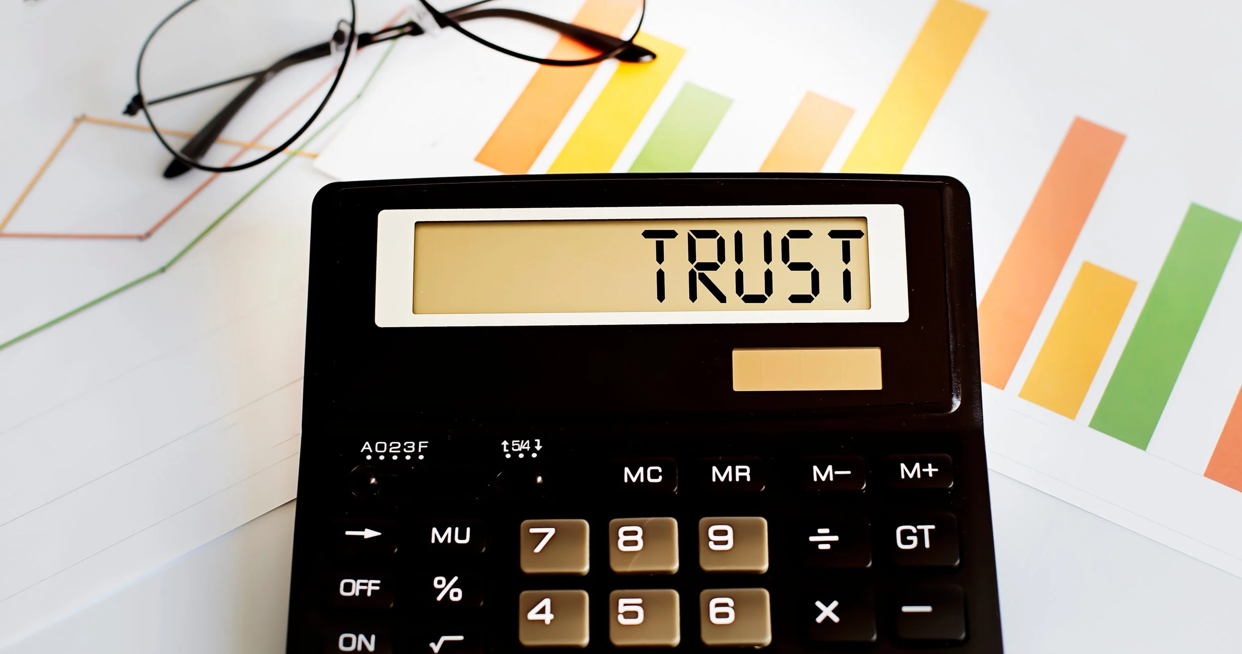 A close-up of a calculator displaying the word “TRUST” on its screen, symbolising accuracy, transparency, and confidence in financial statement reviews by J O’Connor Pty Ltd.