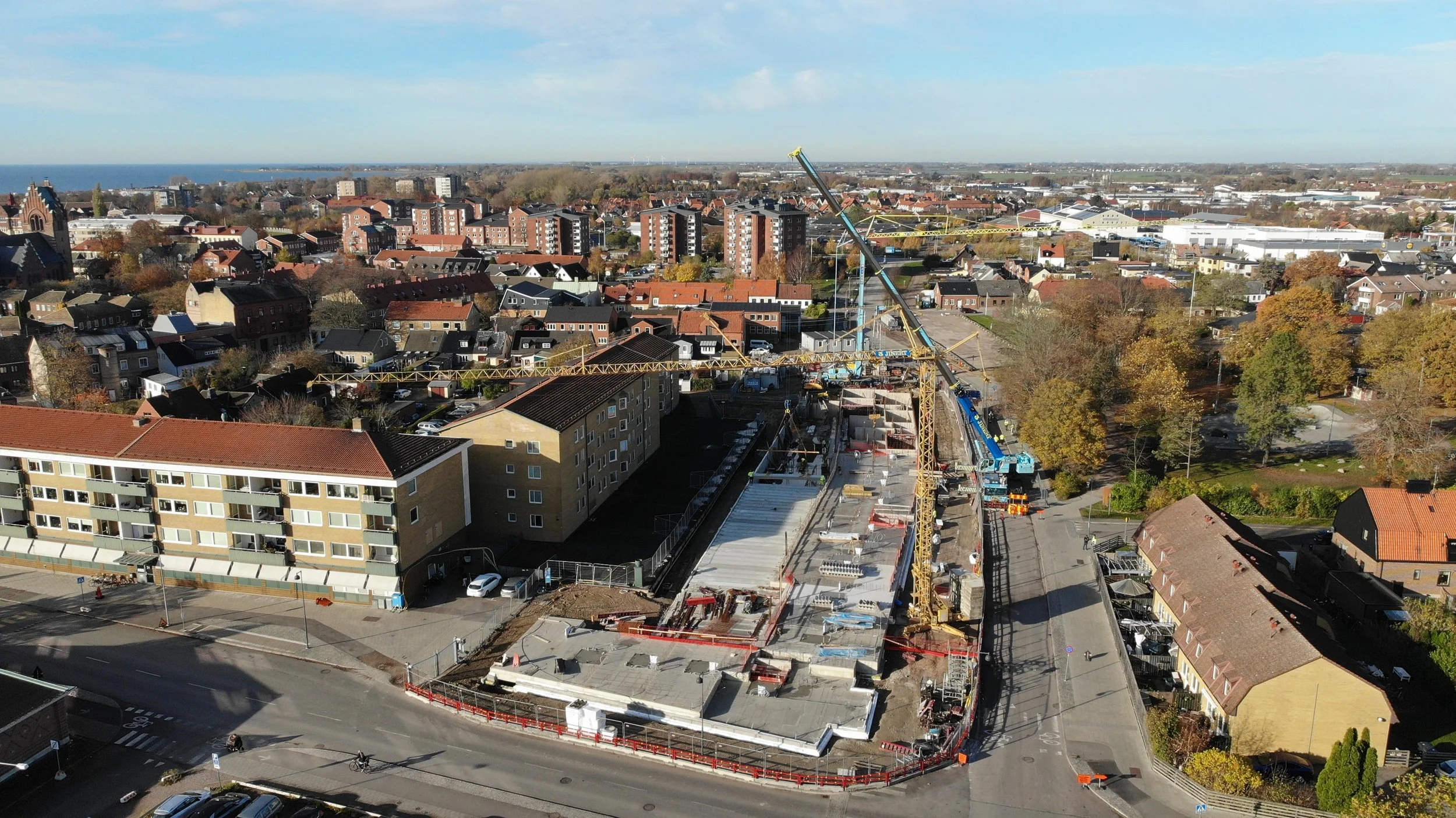 Drönarbild på projektet uppifrån. Tre kranar på plats.