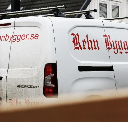 En vit lätt lastbil med Rehn Byggers röda logotyp.