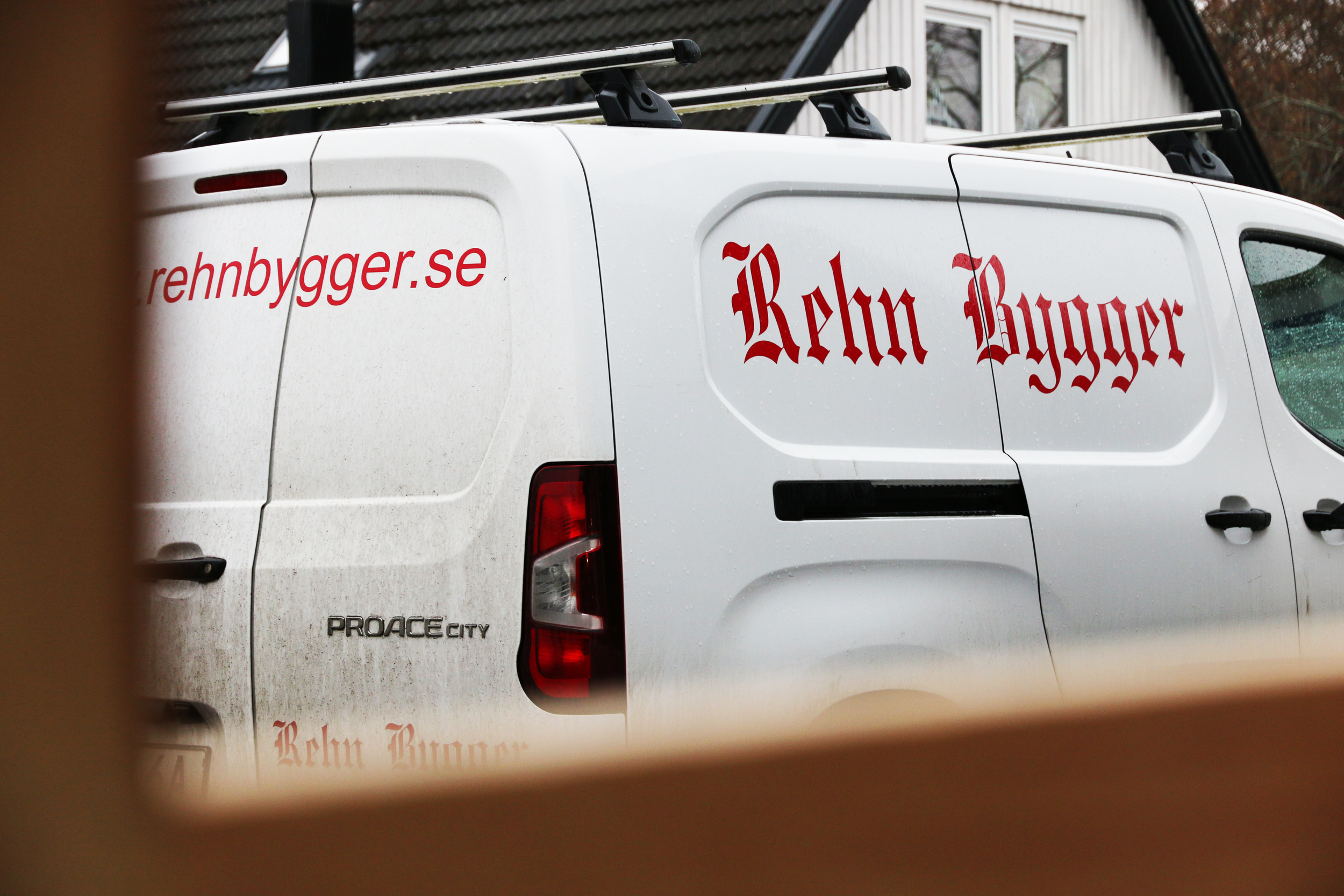 En vit lätt lastbil med Rehn Byggers röda logotyp.
