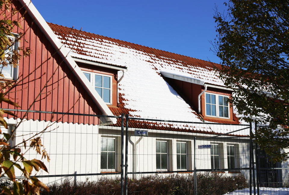Rött snötäckt tak på ett vitt hus som renoveras till lokaler för BUP.