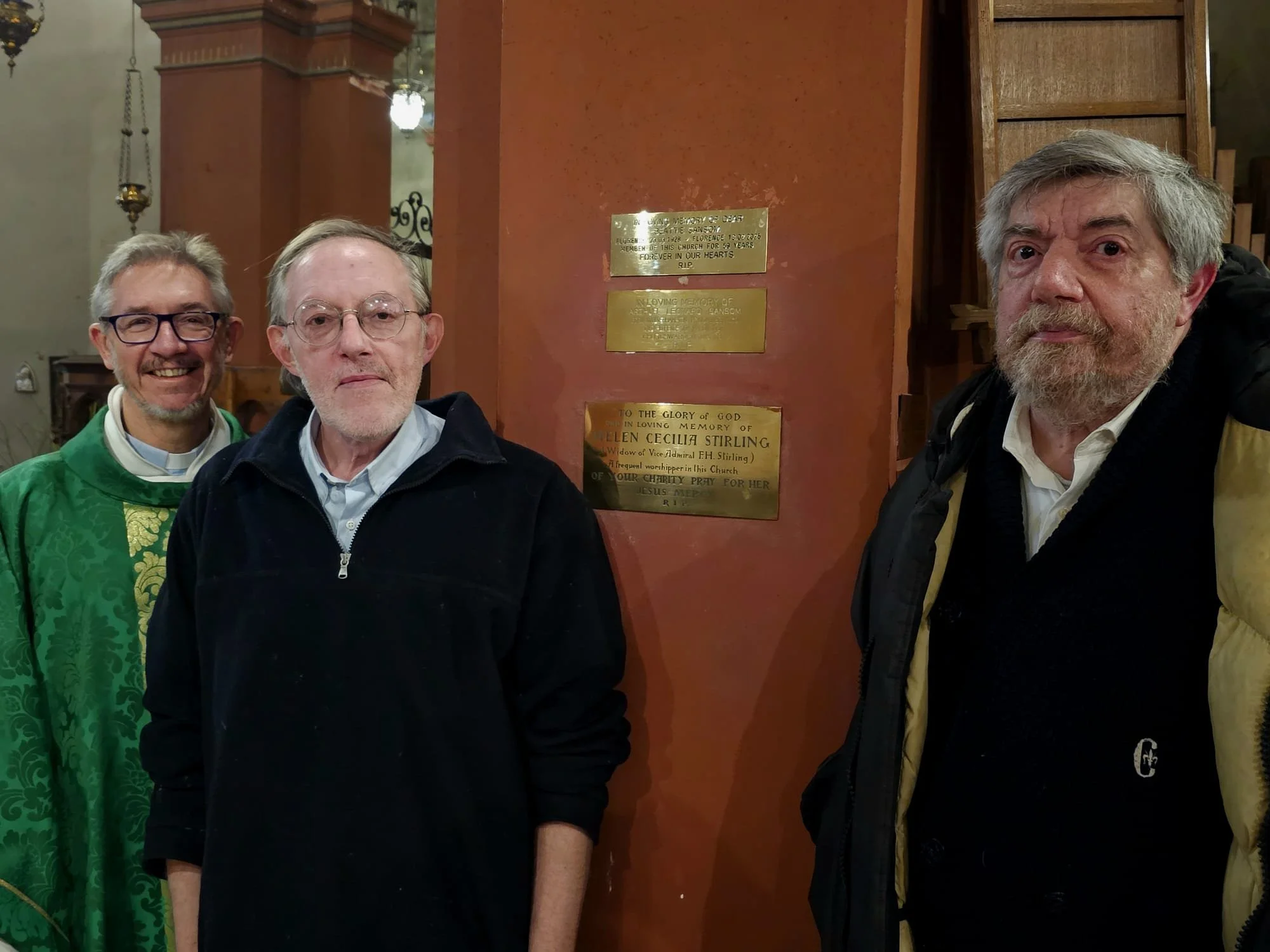 Father Chris, Patrick and Alex Sansom with the new plaque dedicated to their mother Beatty Sansom, a long-time parishioner of St Mark's
