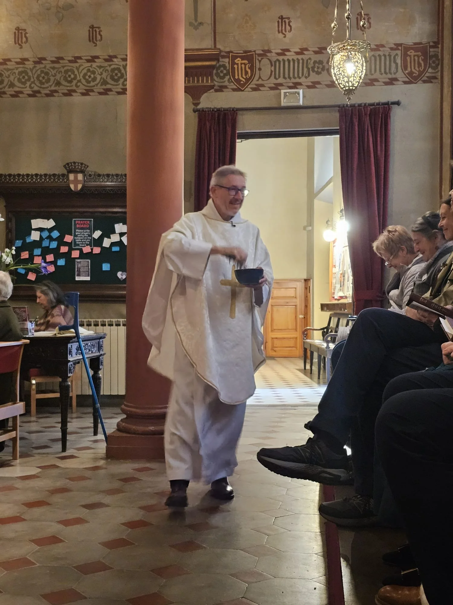 Father Chris sprinkling people with water, as we renew our baptism vows