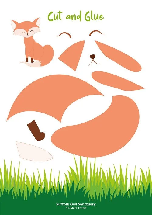 The image shows cut-out pieces of a fox, including its face, body, tail, and legs, with a small illustration of a smiling fox in the top left corner. It appears to be a craft activity for children, with the instruction to cut and glue the pieces to assemble the fox. The background is green with a grassy area at the bottom, and the text 