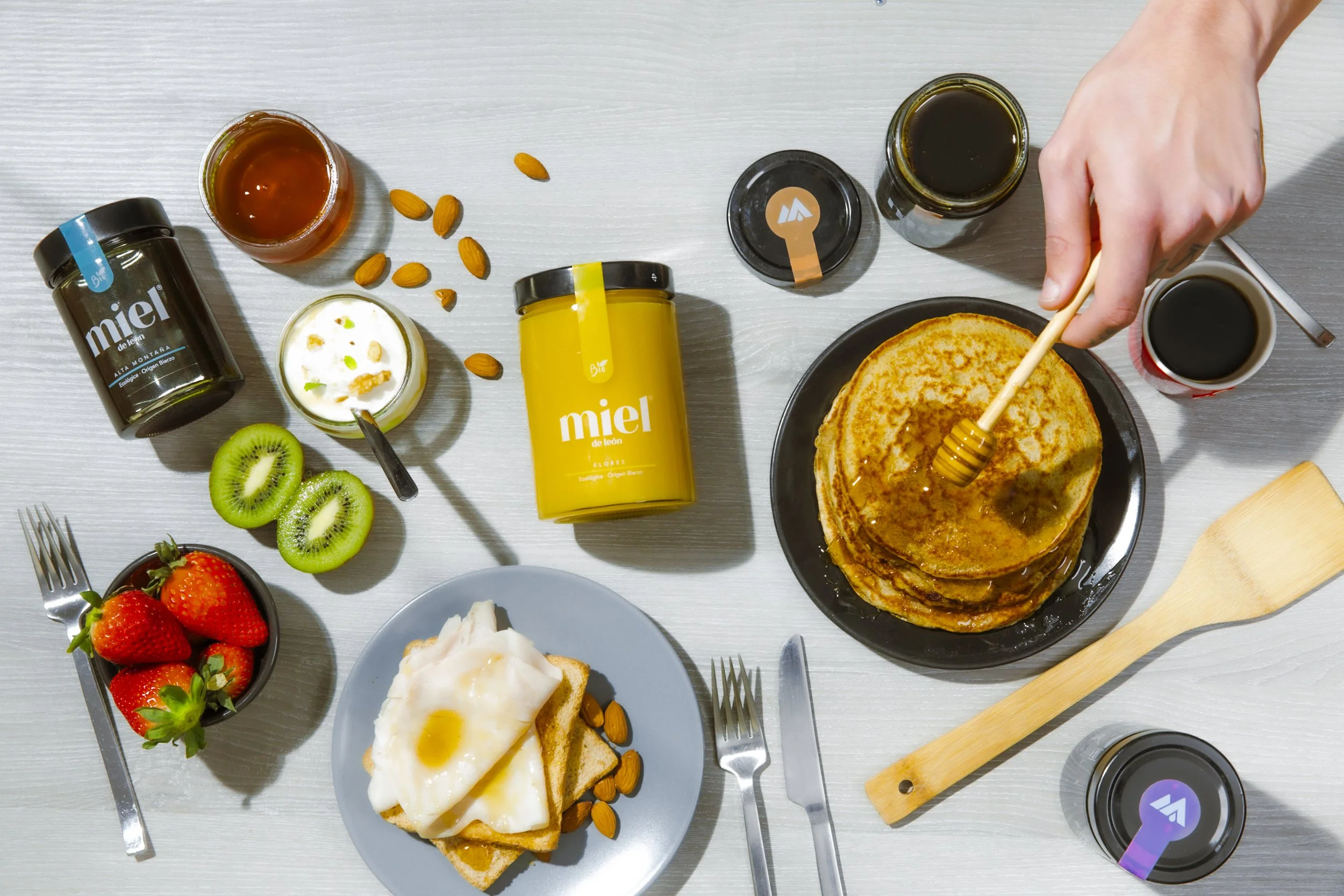 Desayuno con panqueques, miel, huevos, frutas, y bebidas.