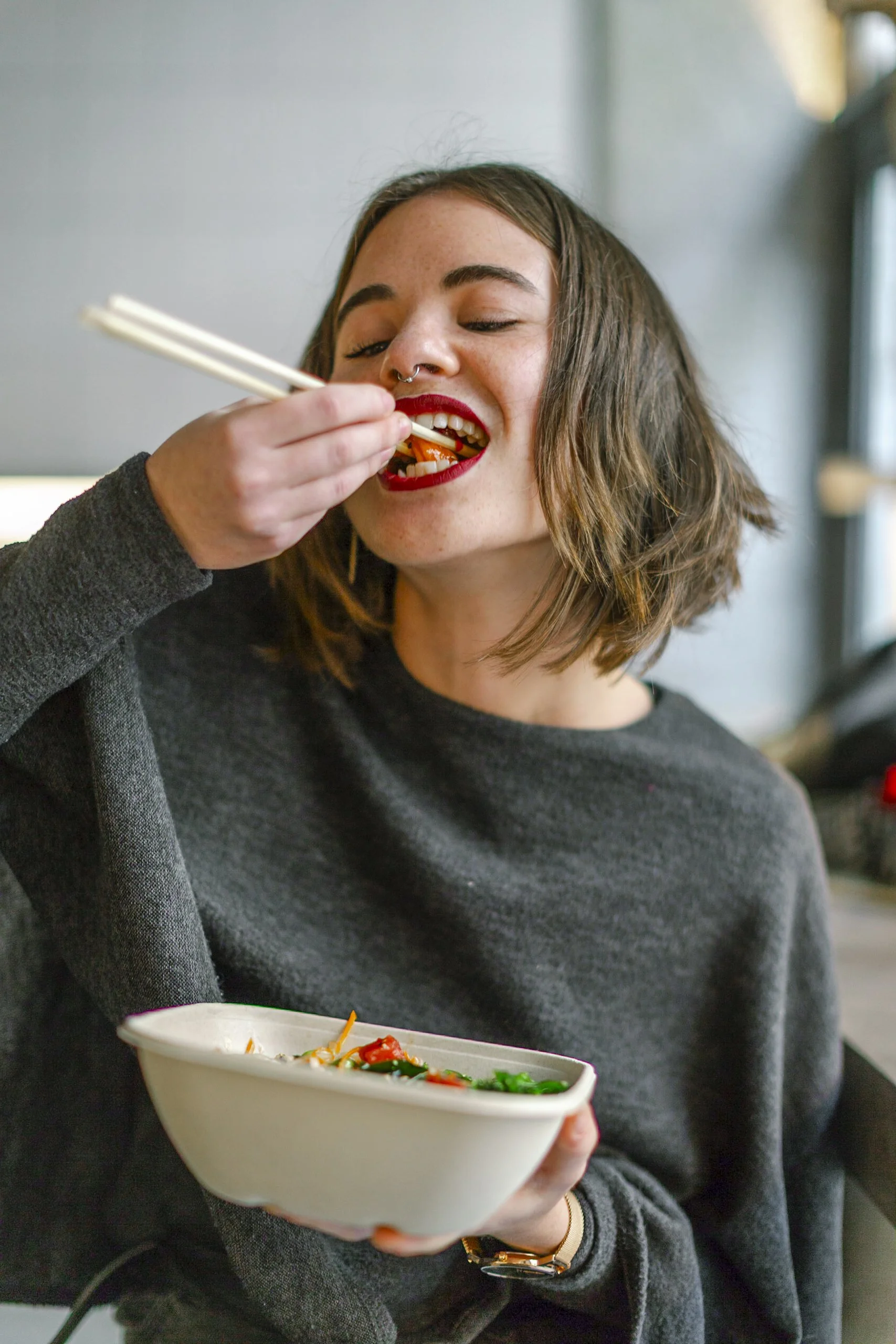 Jovencena comiendo ramen en un restaurante.