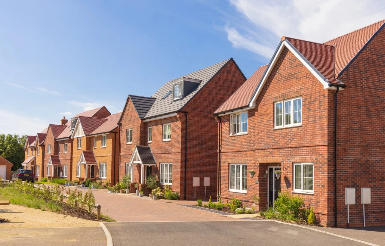 Five red brick houses down a street