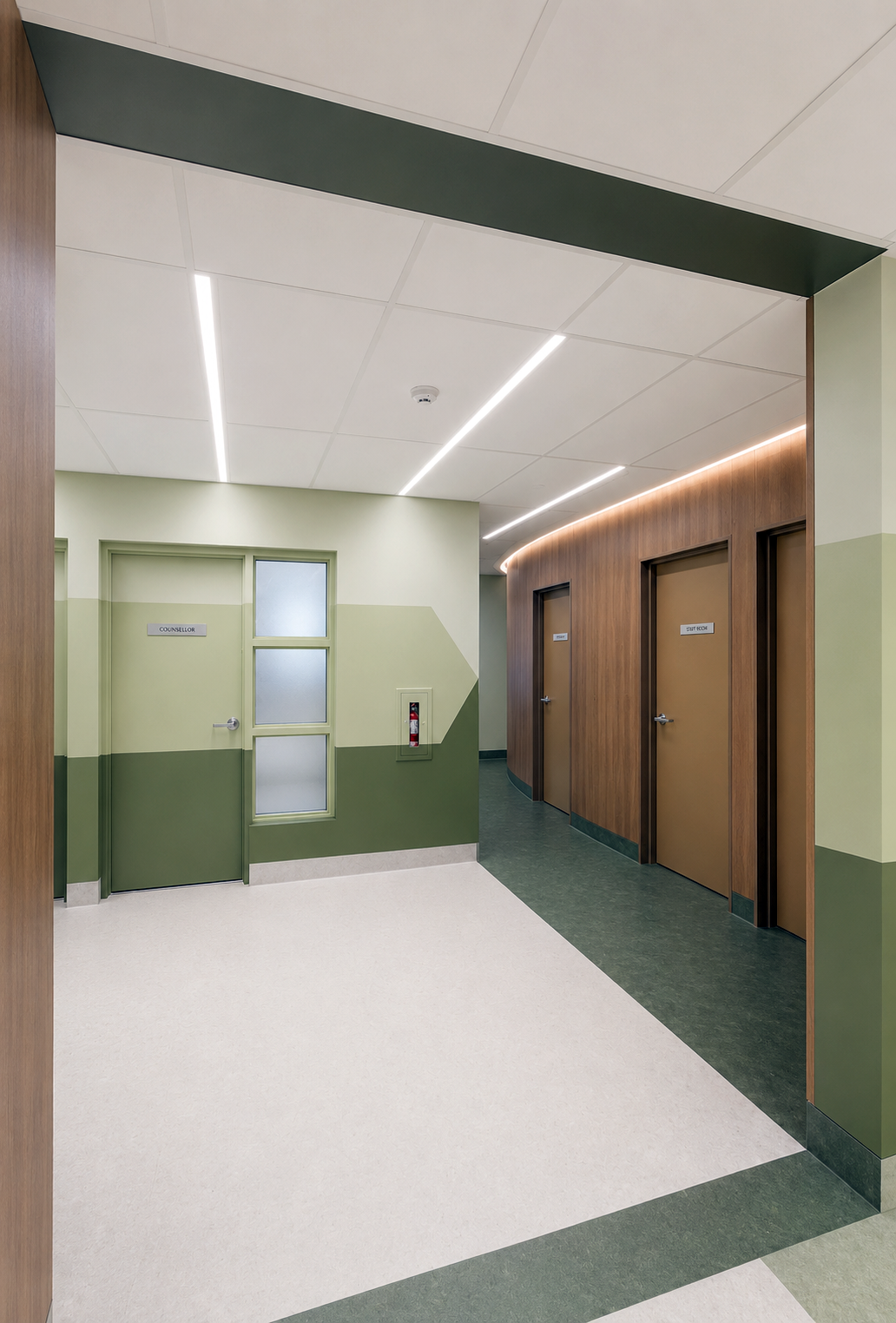 Modern hospital corridor with green and wood panel walls, frosted glass door labeled 'Counsellor', and three doors labeled 'Study Room'. Ceiling has recessed lighting and a fire extinguisher is mounted on the wall.