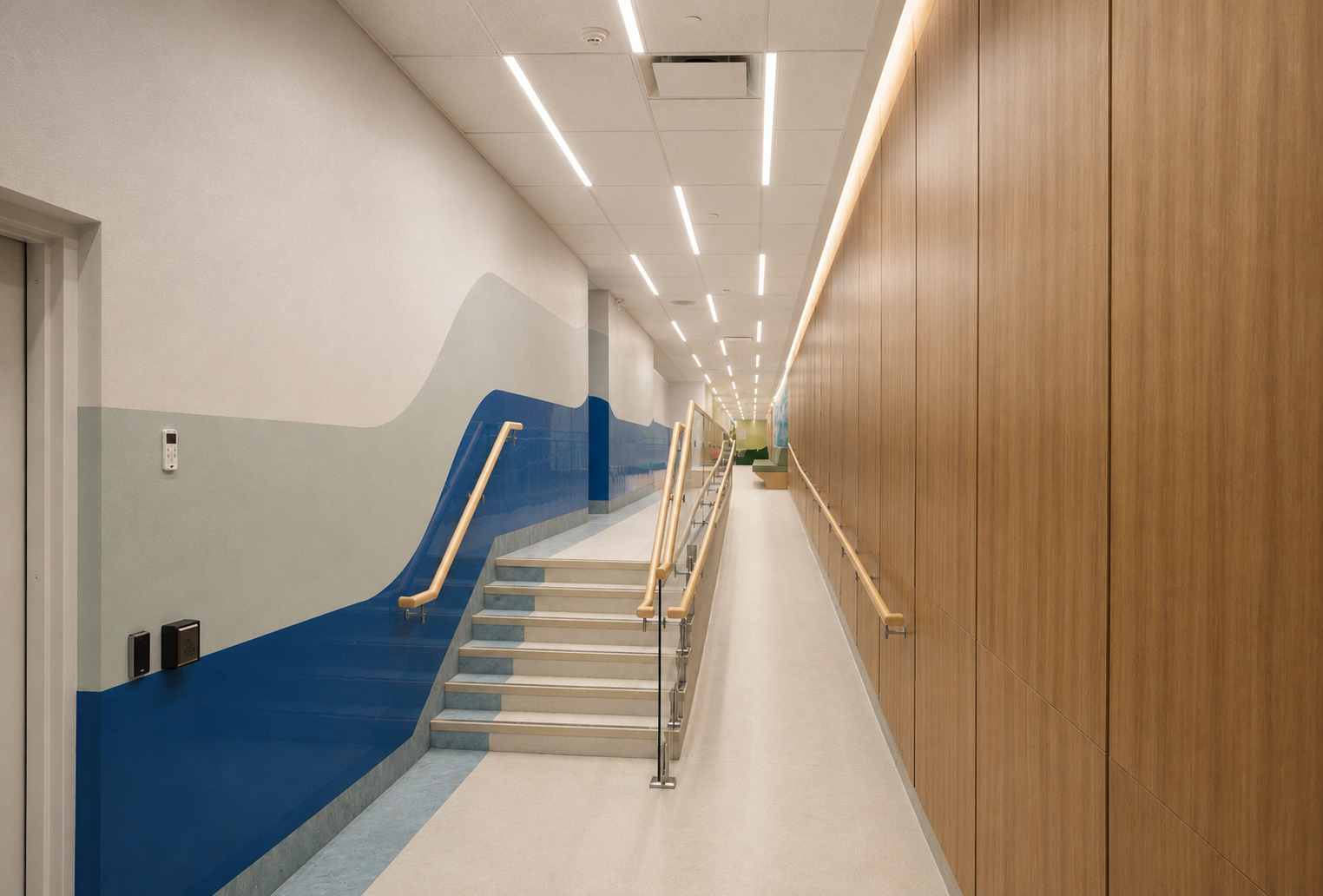 A modern indoor hallway with a staircase, wooden panel wall on the right, wall painting of a mountain and water on the left, ceiling lights, and handrails.
