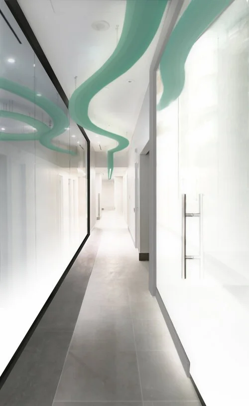 Empty, modern hallway with white walls, glass panels, and a wavy green ceiling design.  Healthcare Architecture. wellbeing and wayfinding. salutogenic design. Inspiration for Toronto, Dallas, Park city, Texas, Miami.