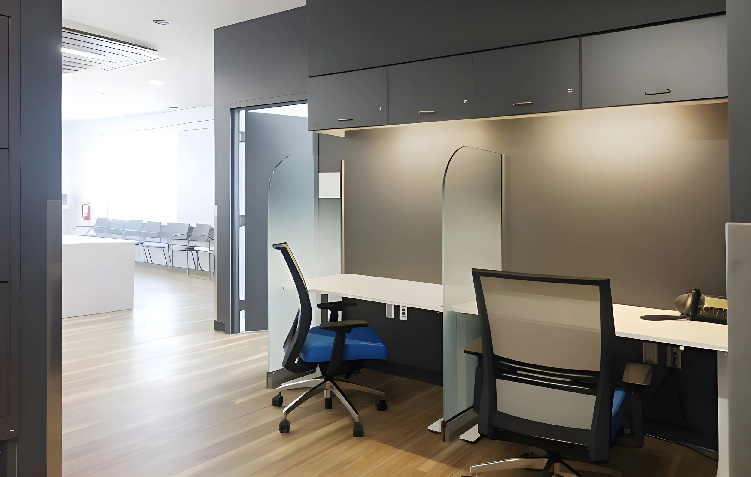 Modern office space with workstations, black chairs, and partition walls in a bright environment with natural light