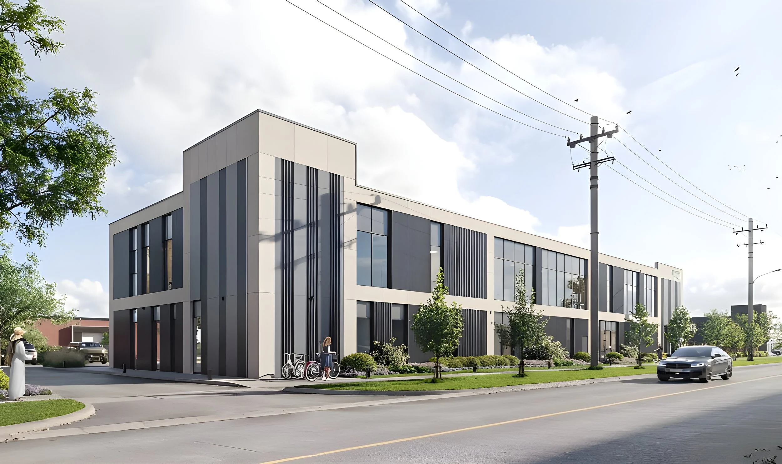 Modern building with large glass windows, trees, and a few bicycles parked outside. Cars are driving on the street in front of the building. Overhead power lines and birds perch on the power poles. Cloudy sky with some sunlight.