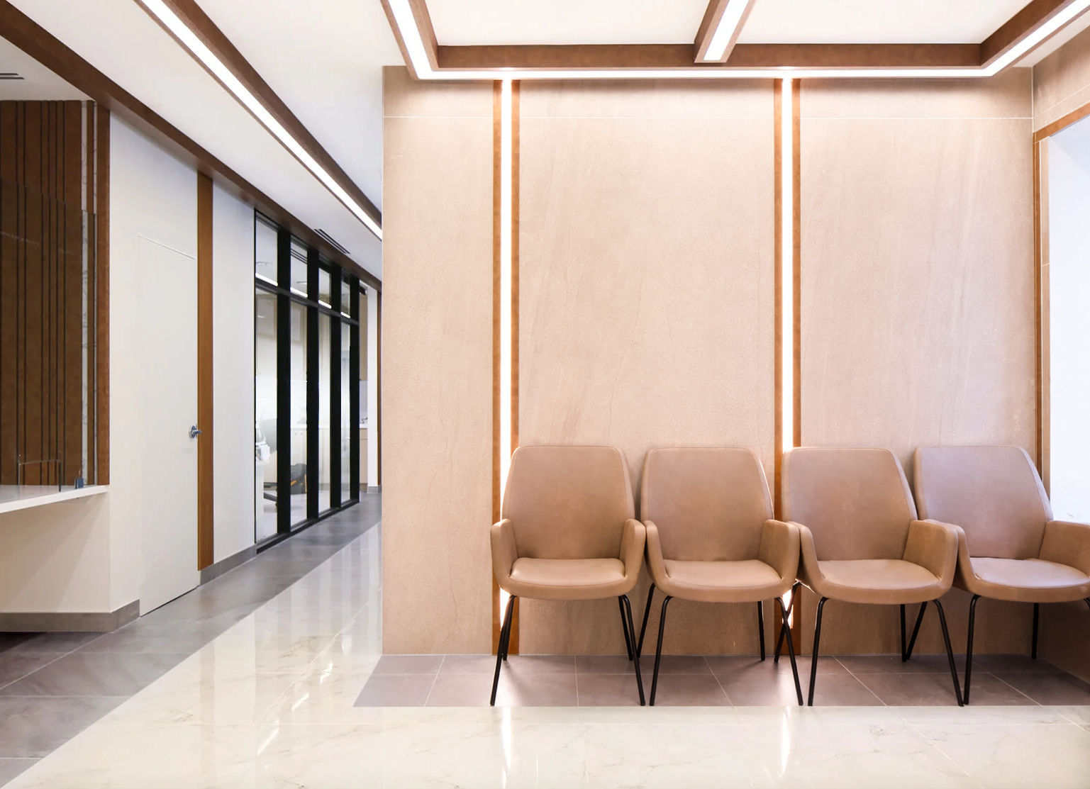 A row of four beige chairs with armrests and metal legs lined up against a beige wall with vertical lighting accents in a modern waiting area.  Healthcare Architecture. wellbeing and wayfinding. Inspiration for Toronto, Dallas, Park city.