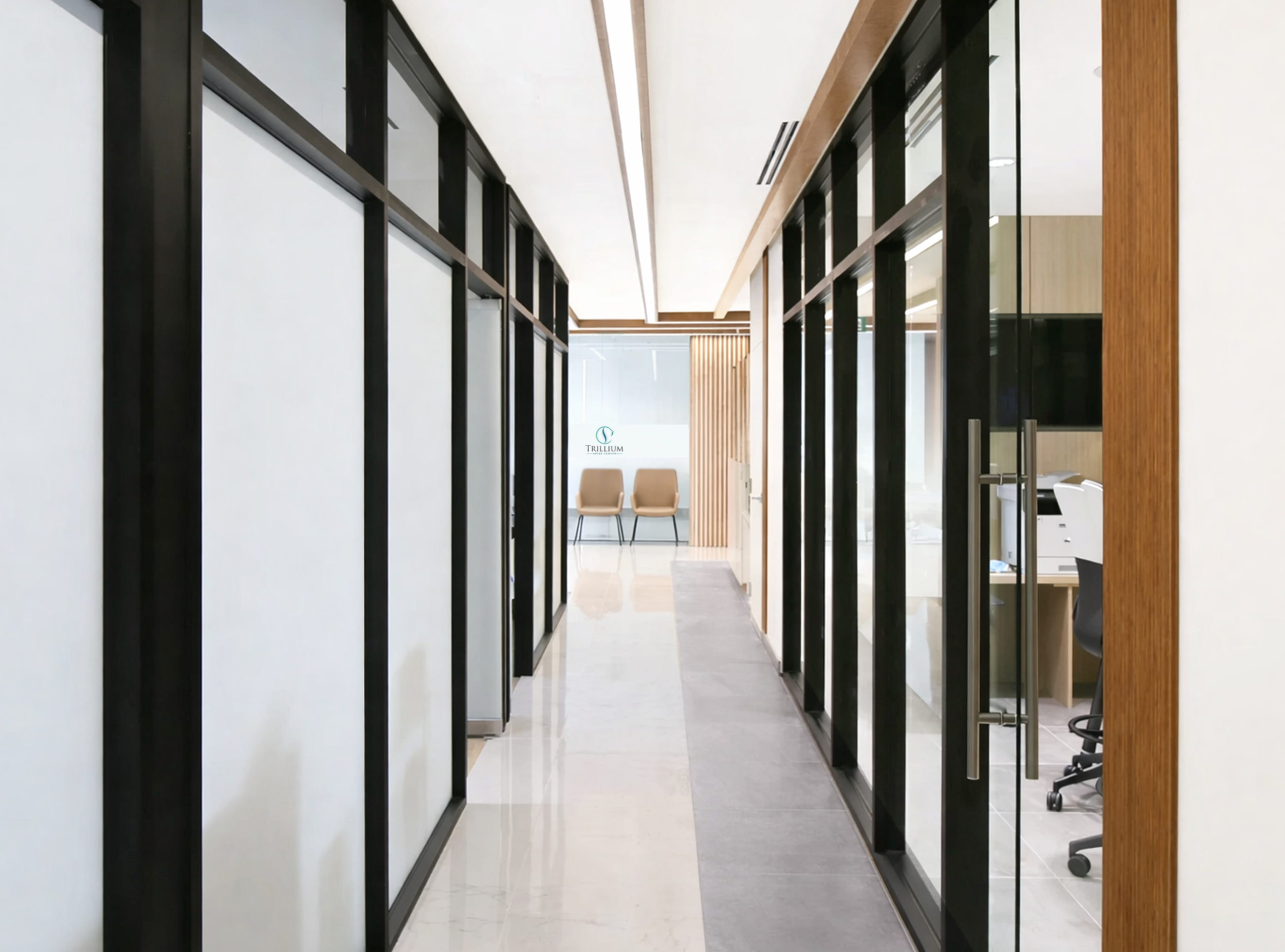 Modern office corridor with glass walls and chairs at the end. healthcare Architecture. wellbeing and wayfinding. salutogenic design. Inspiration for Toronto, Dallas, Park city, Texas, Miami.