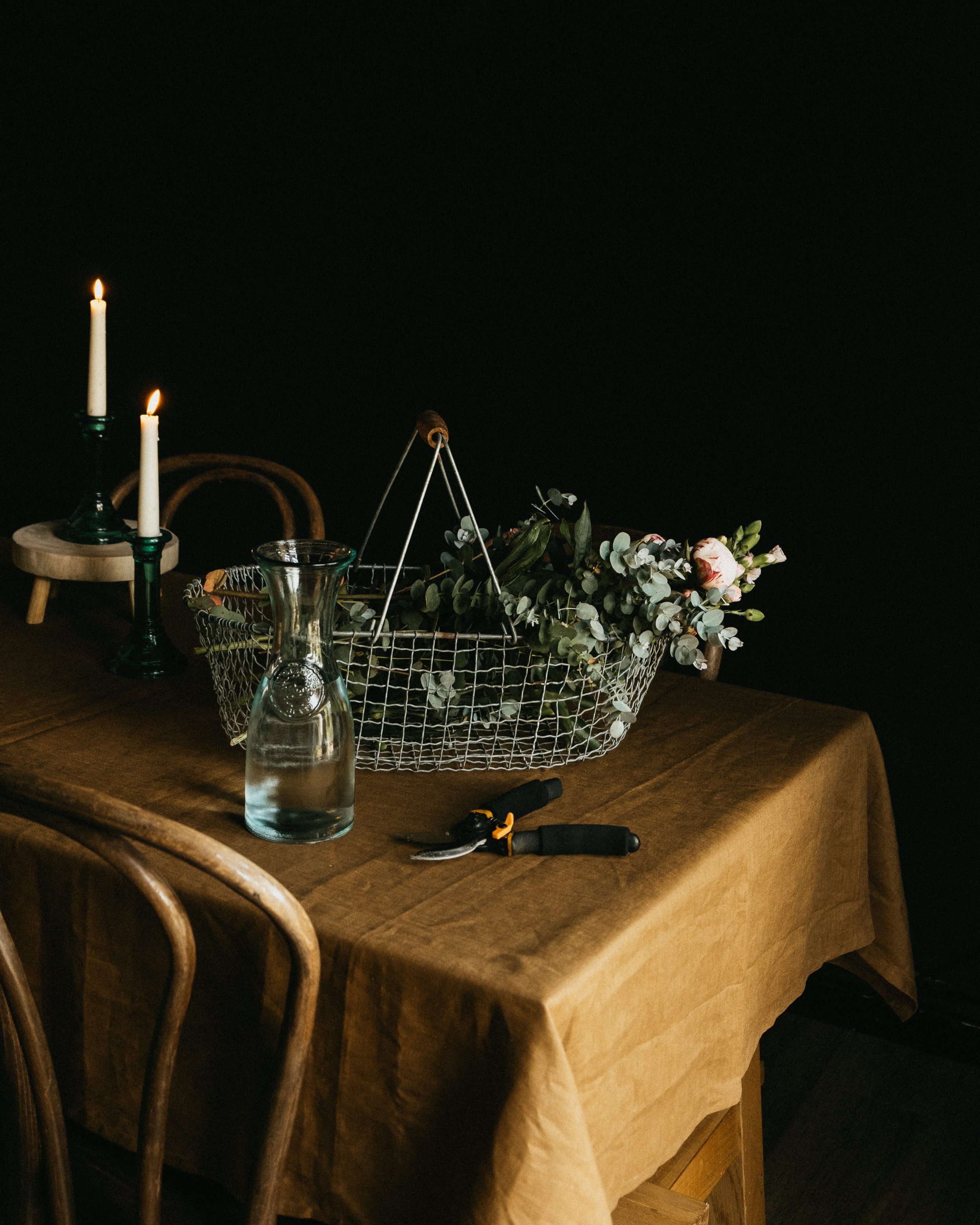 Snippets from a photo shoot, featuring a flower basket, a linen tablecloth and candles. Part of a series for CrisannaBoutique, my photography captures the magic of slow, every day moments, and seamlessly incorporate the products of the brand in the i