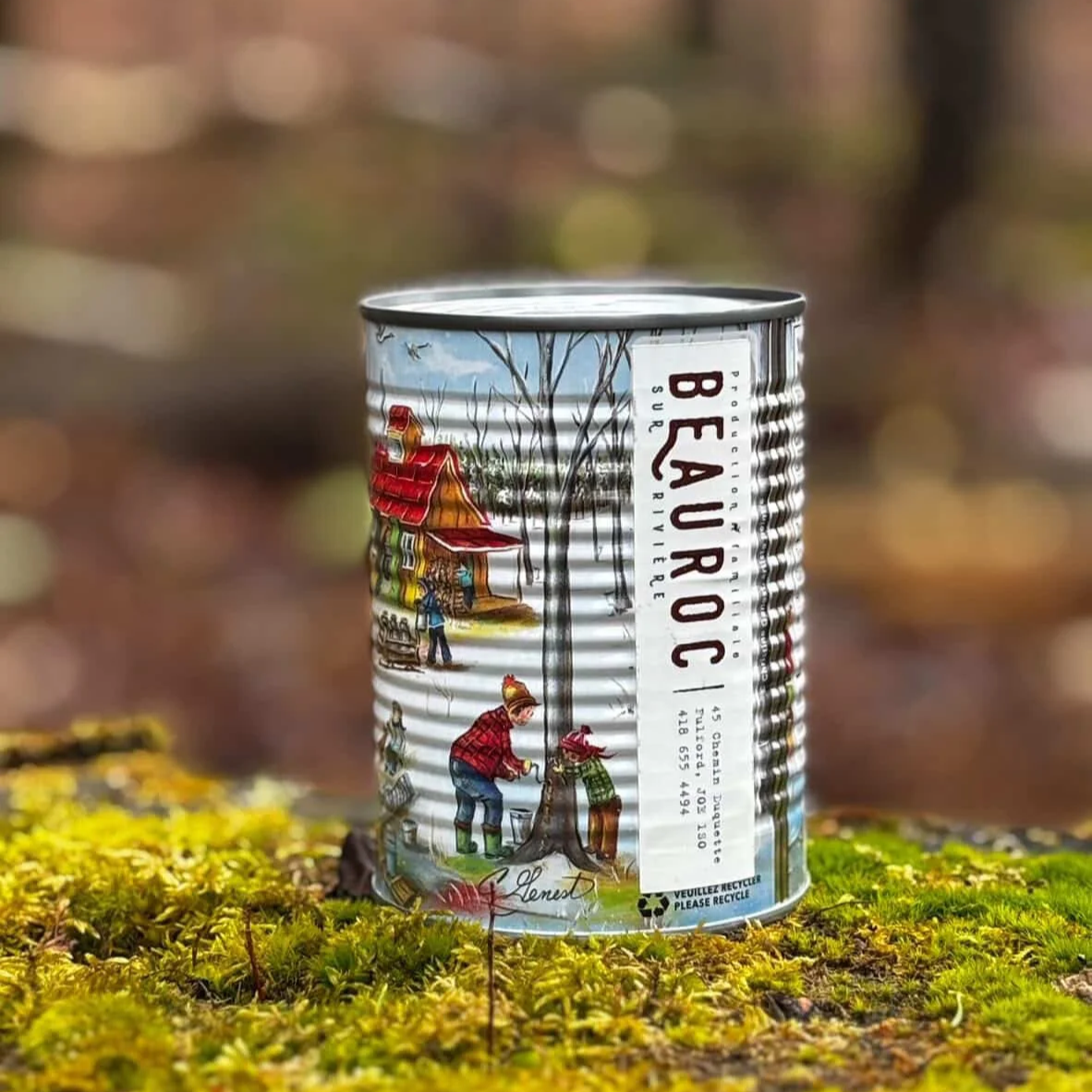 Can of Canada maple syrup placed on a bed of moss in the forest