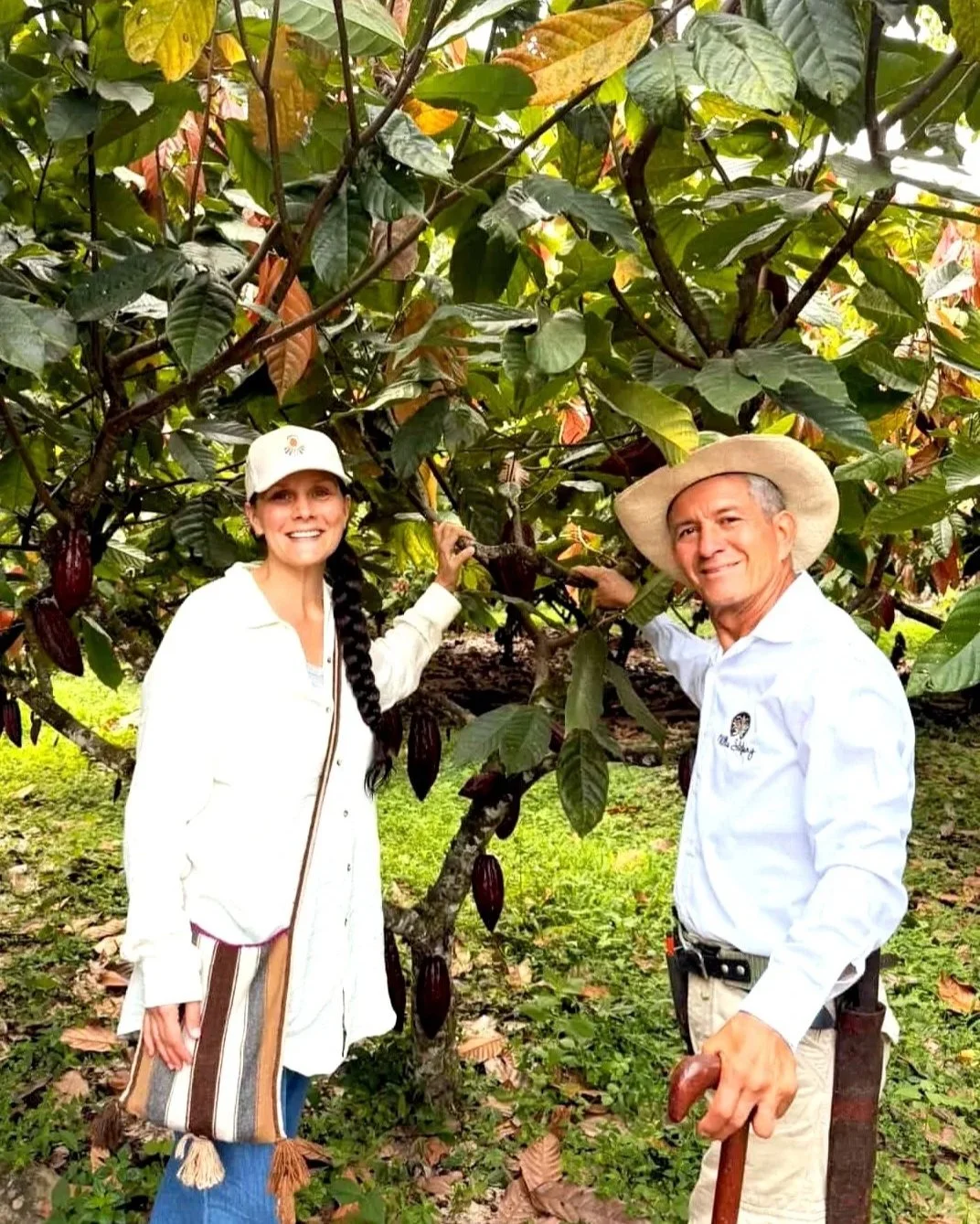 Maman Cacao founder and Bernardo from Caonia Cacao smiling in front of a Cacao tree