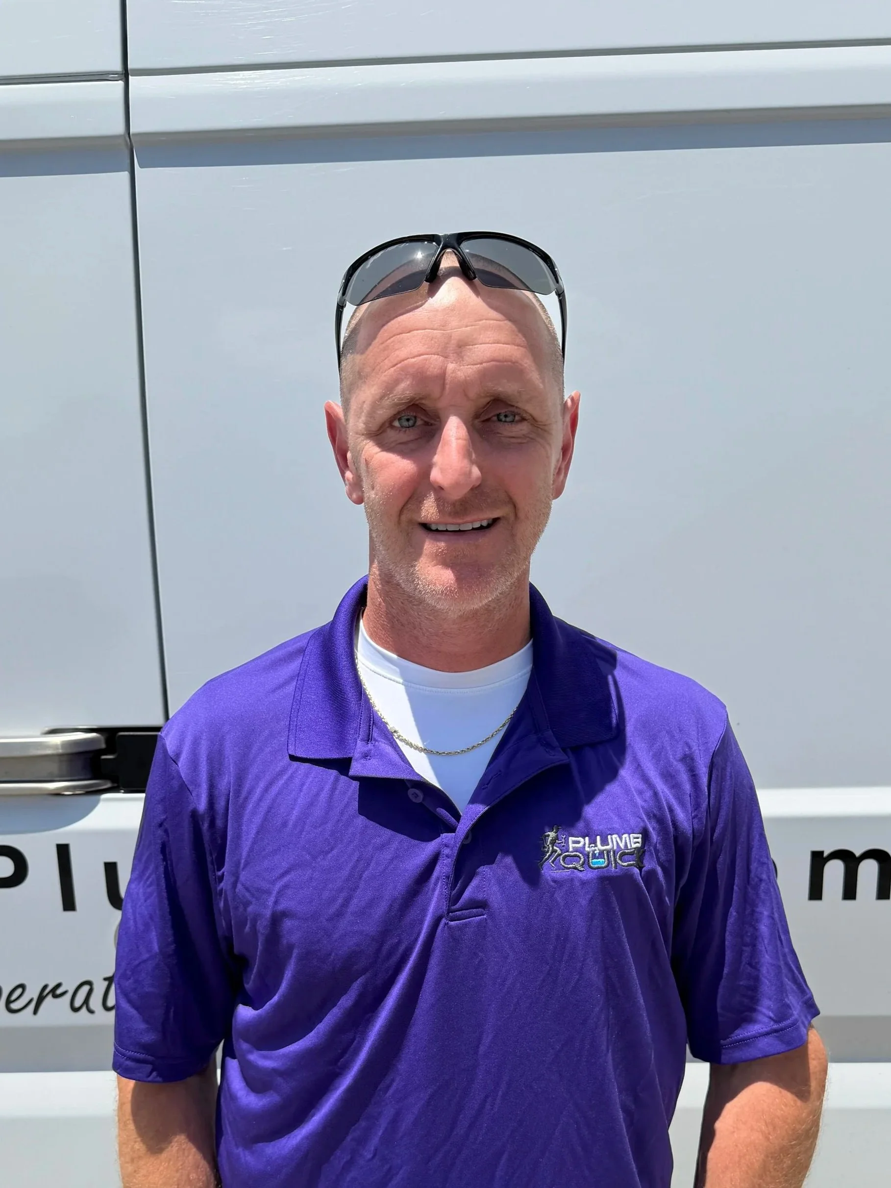 Matthew Haynes, Master Plumber at Plumb Quick, standing in front of a company service vehicle