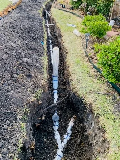Residential sewer line replacement trench with new PVC pipe installed in Plano Texas