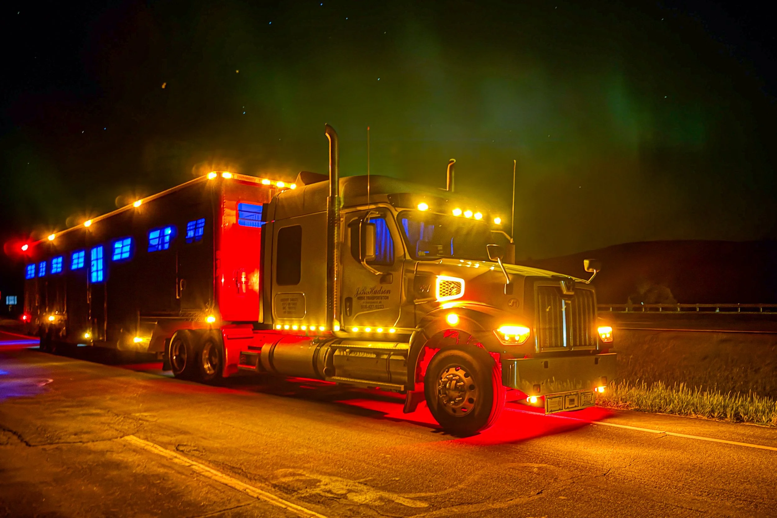 J.R. Hudson Horse Transportation Western Star and 16 horse trailer under the northern lights after unloading at Spruce Meadows
