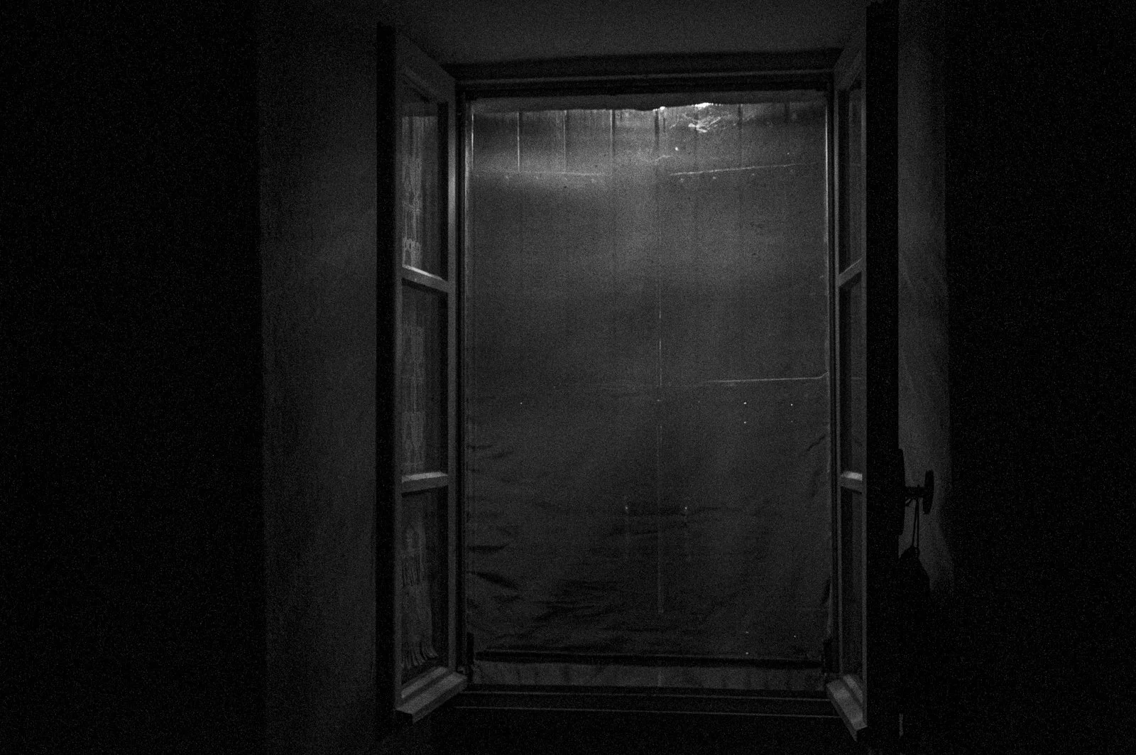 Open door leading to a dark, empty, enclosed space with a faint light coming from the outside.