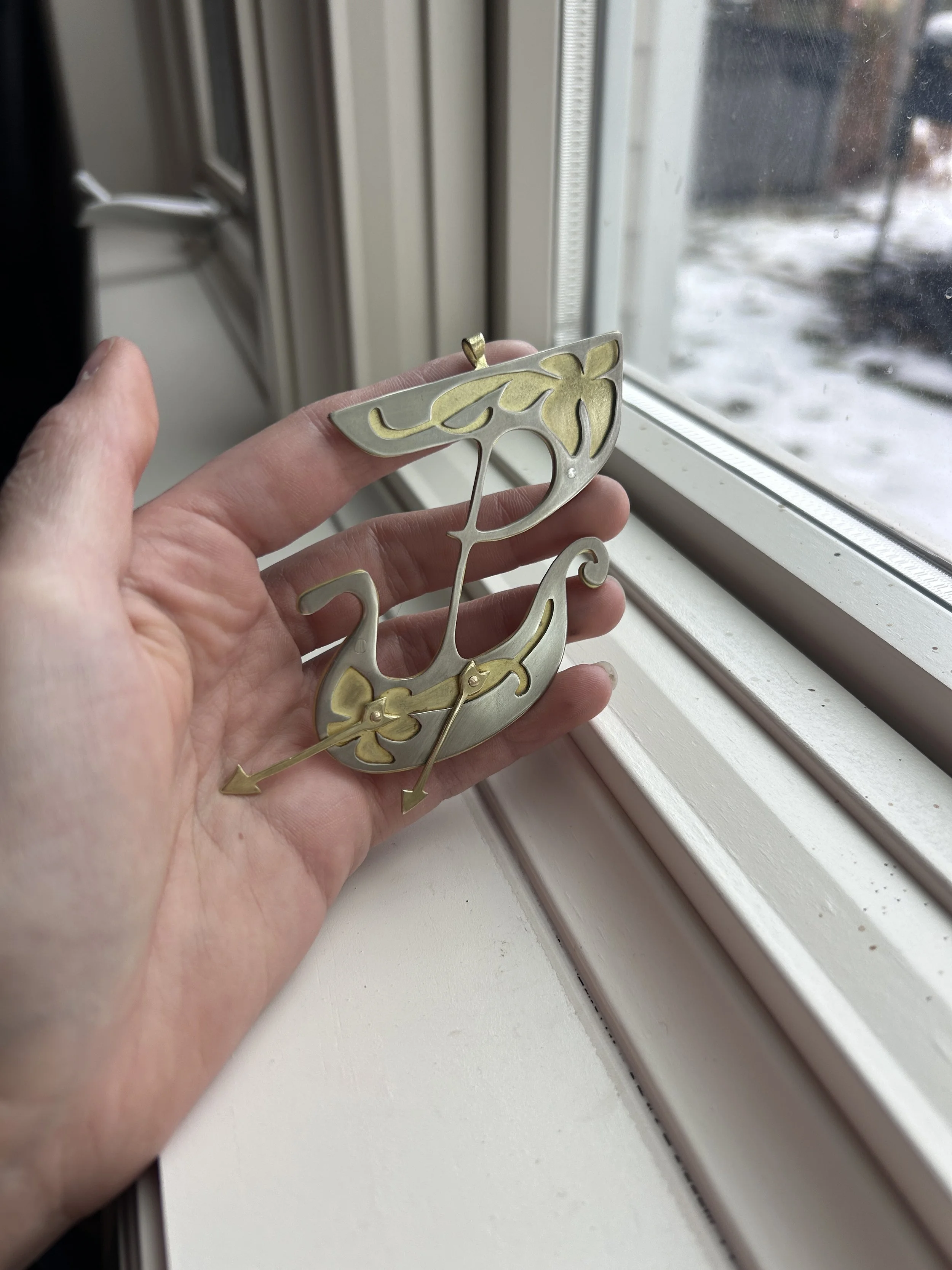 Pendant in nickel and brass, hand-sawed and riveted together