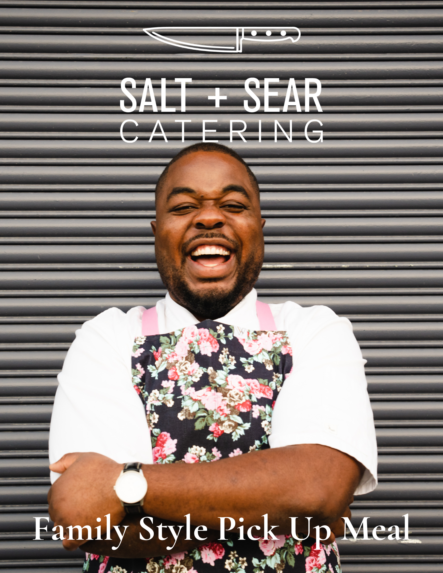 A man wearing a floral apron stands smiling with arms crossed in front of a corrugated metal background. The text reads: 'Salt + Sear Catering' with a knife logo, and 'Family Style Pick Up Meal' below.