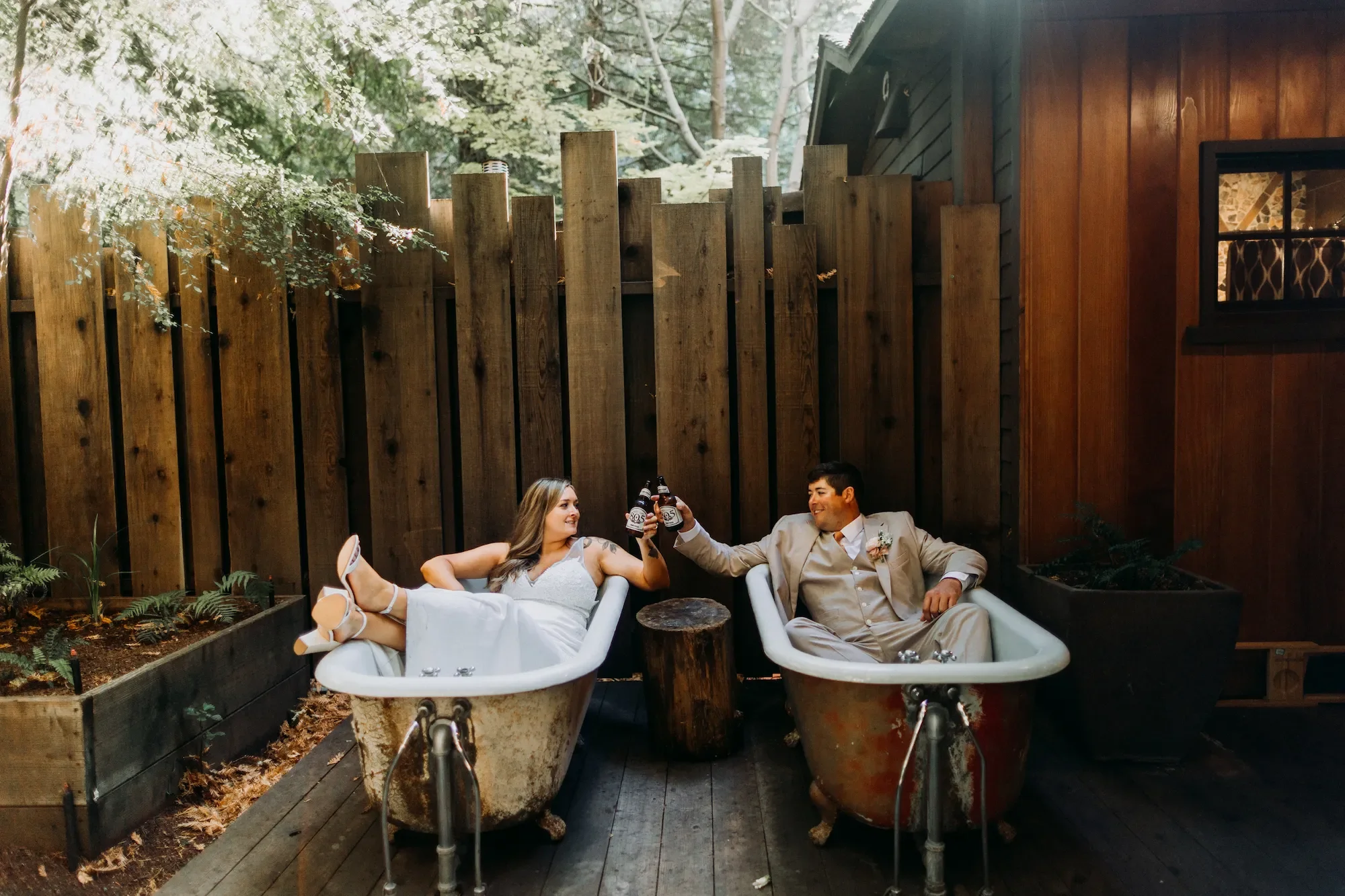 April and Trey sharing a cheers in outdoor tubs during their Big Sur Elopement