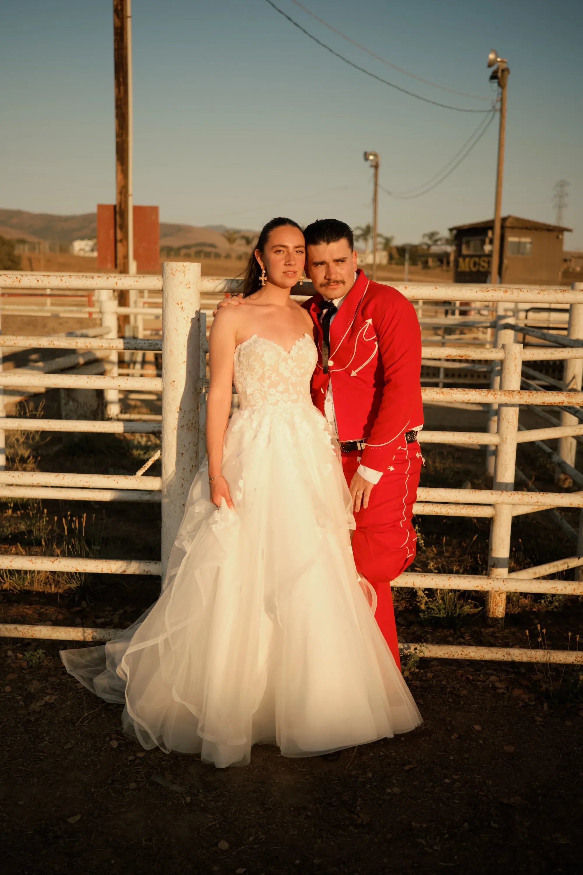 Danielle and Rhett posing by a fence during golden hour with Partial Planning Services