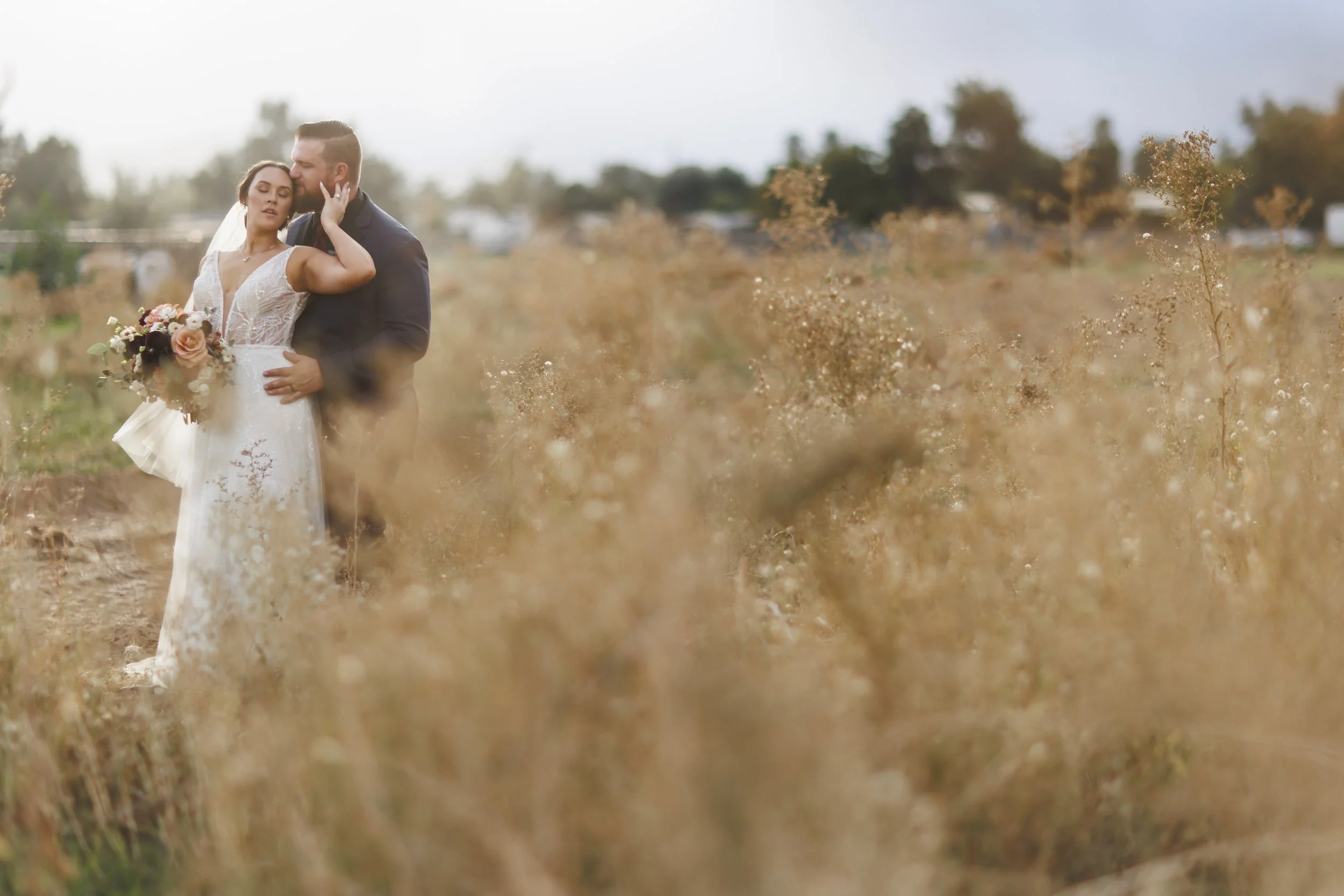 Carmel Valley Day of Coordination planning with bride and groom standing in field and holding one another