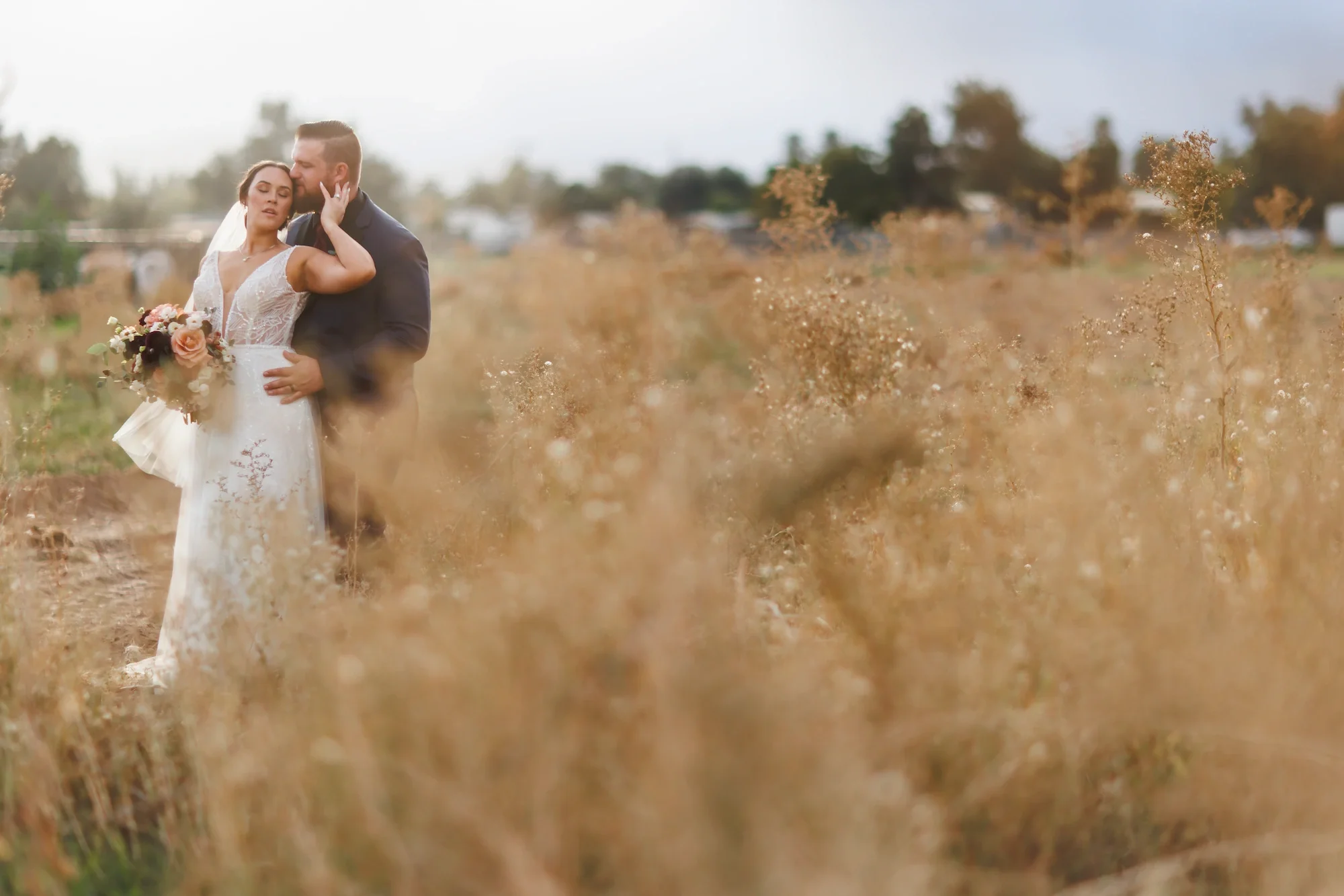 Carmel Valley Day of Coordination planning with bride and groom standing in field and holding one another
