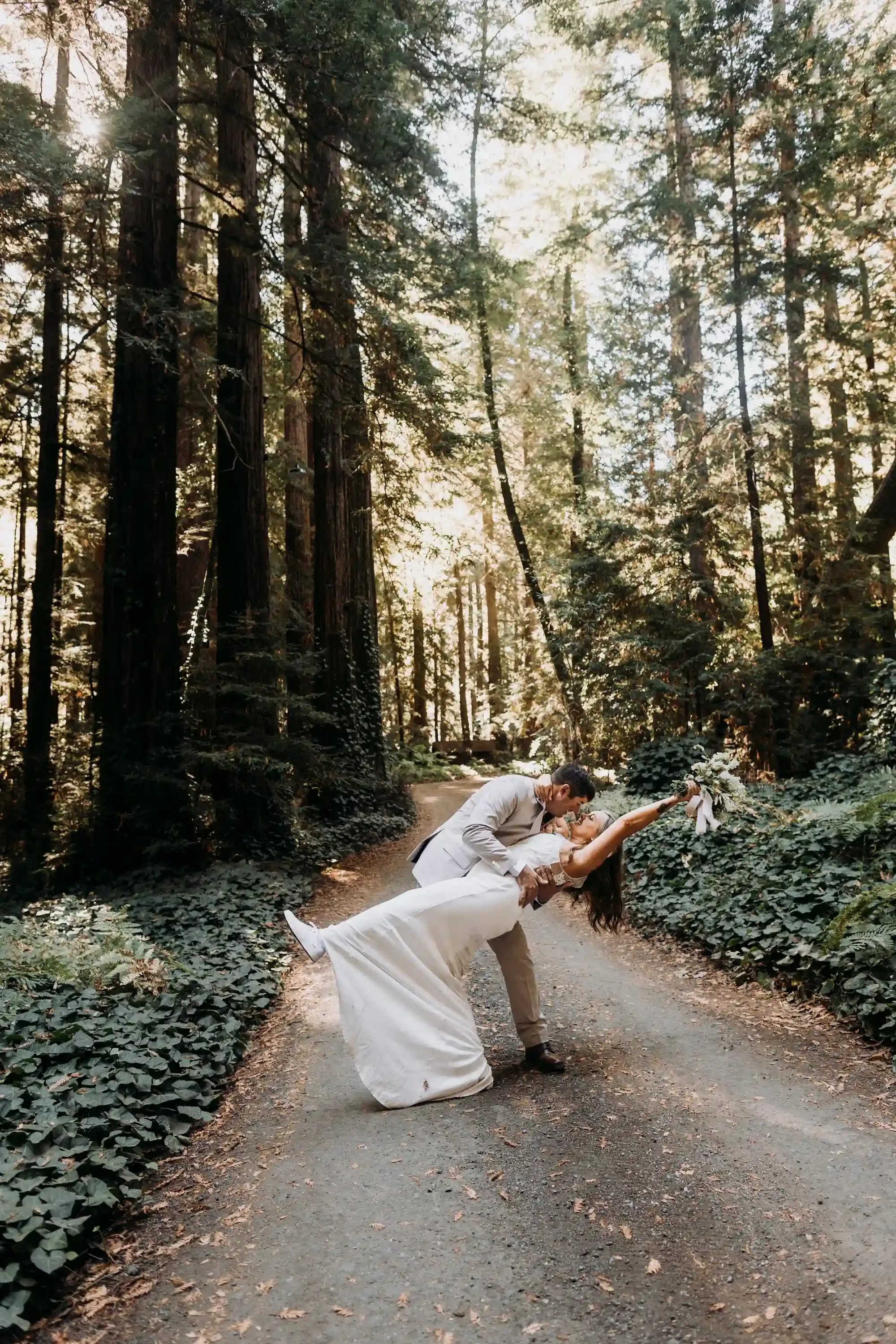 April and Trey sharing a kiss and a dip in the forest during their Big Sur elopement