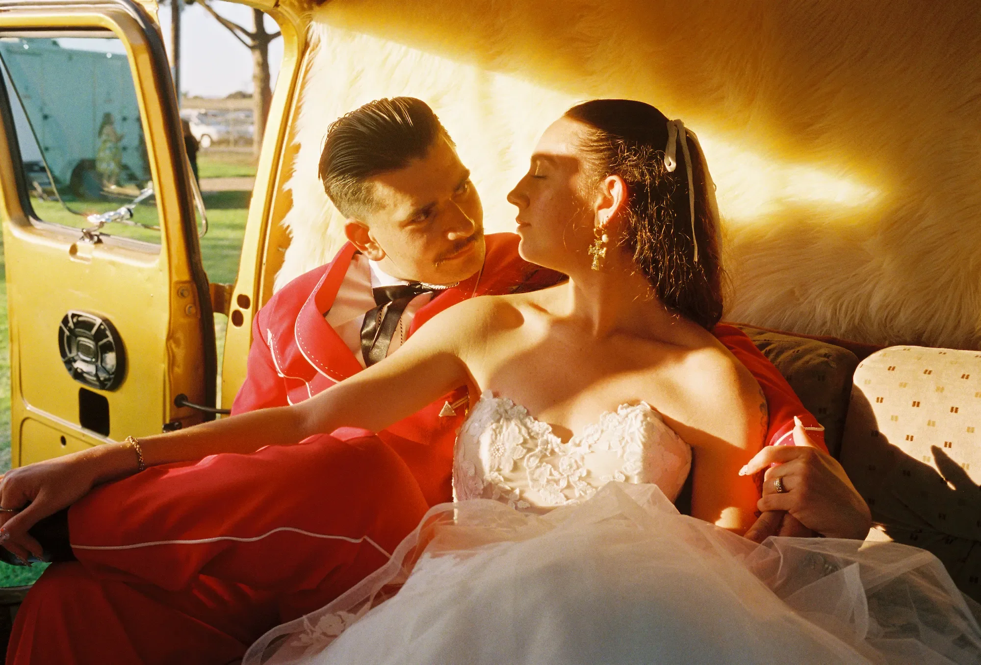 Danielle and Rhett posing in a car with golden sunlight looking at one another with Partial Planning Services