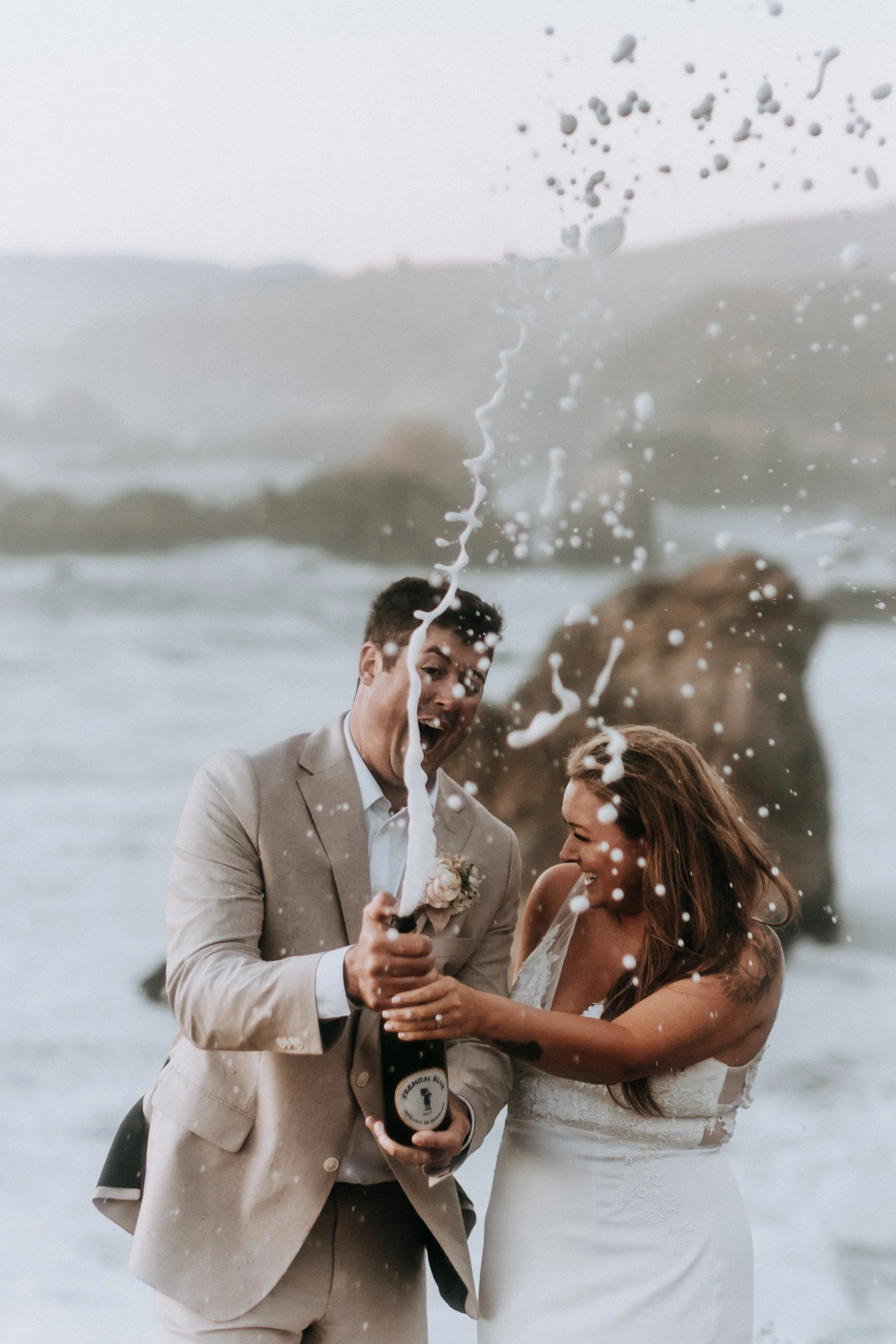 Big Sur California full wedding plan service with our couple celebrating with champagne on a beach