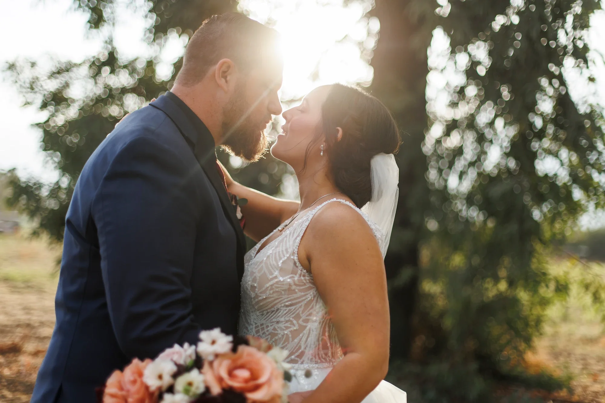 Carmel Valley full-service wedding planned by Love in Bloom Events with bride and groom facing each other embracing for a kiss