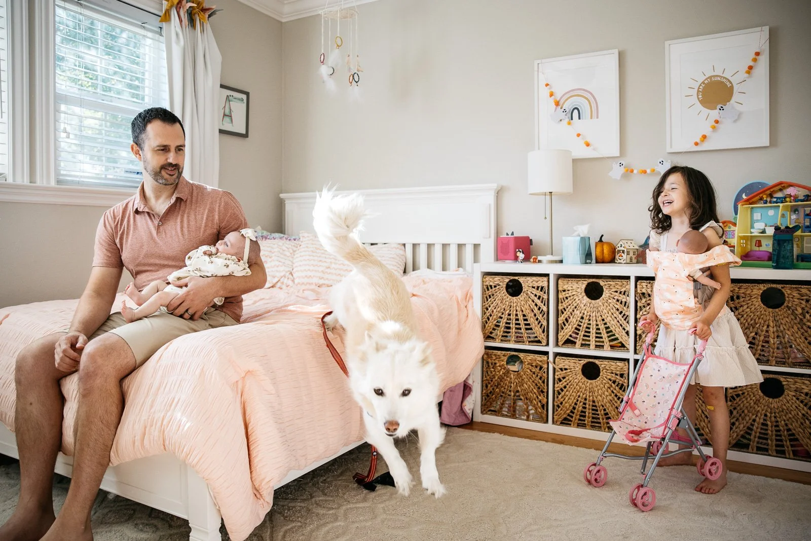 White dog jumps off bed in baby girls bedroom during a newborn photo session in Walnut Creek.