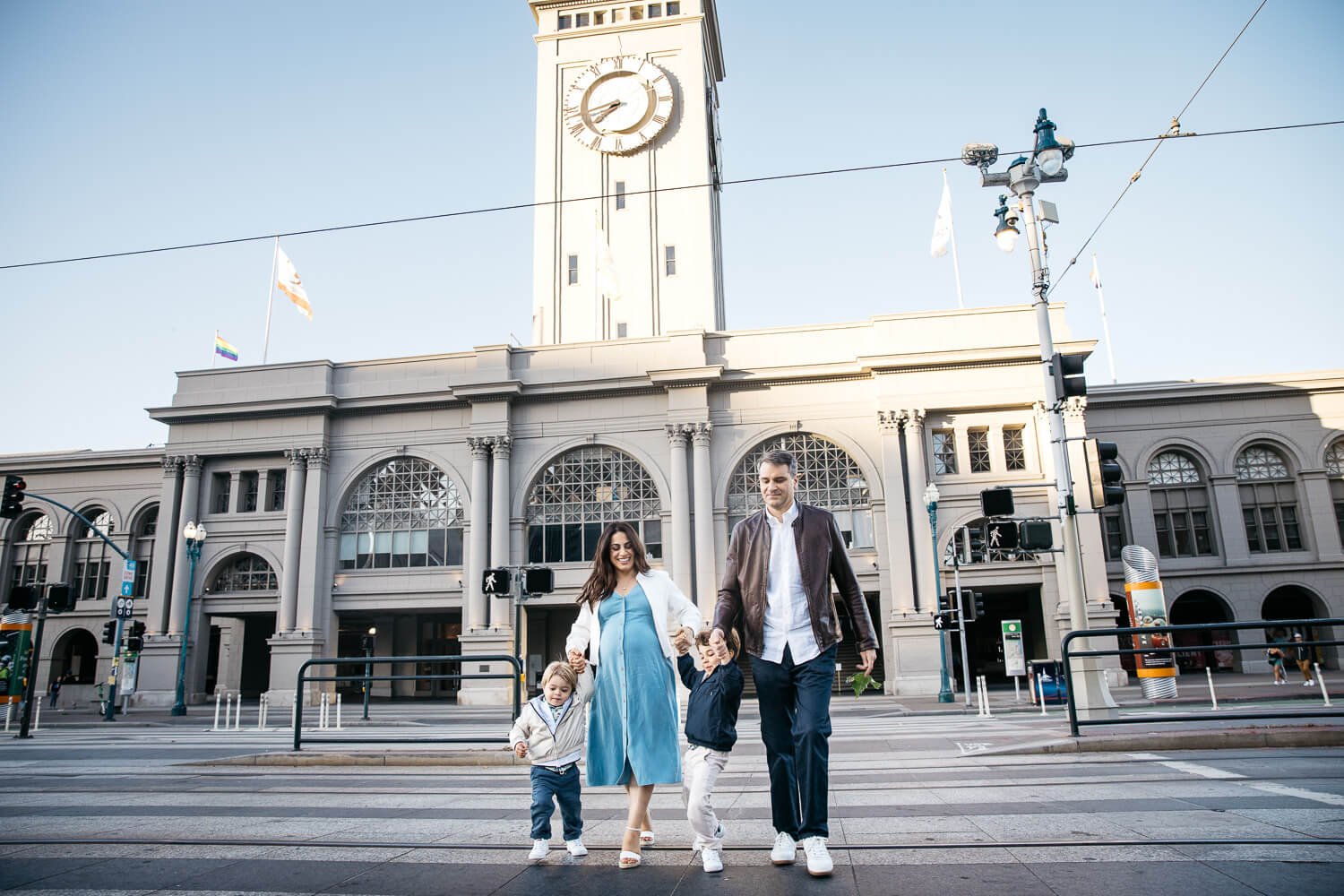 Family of four, with pregant mama, crosses the street in front of Ferry Building in San Francisco.