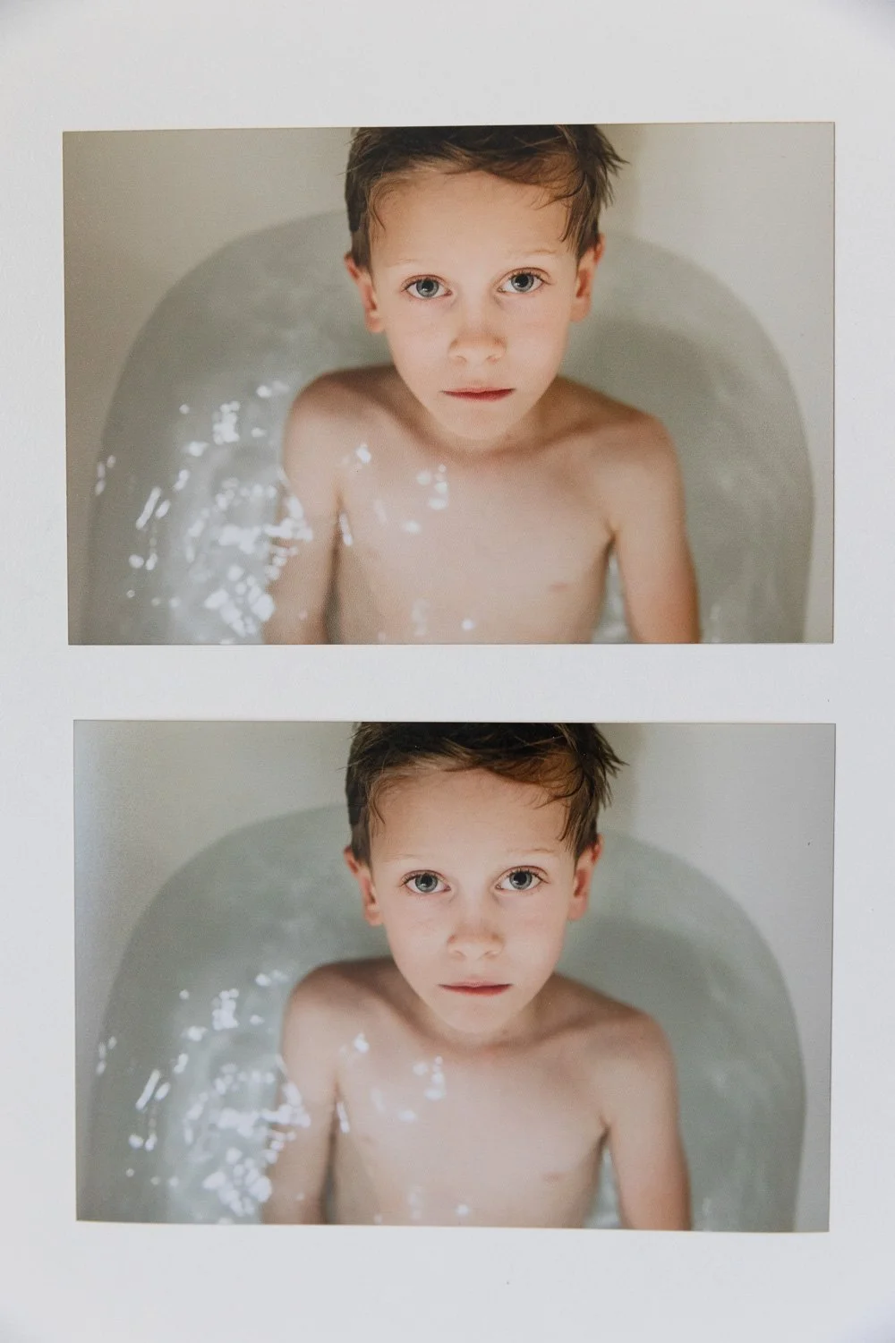 two photo prints of boy in white bathtub looking up at camera, with lustre and matte finishes