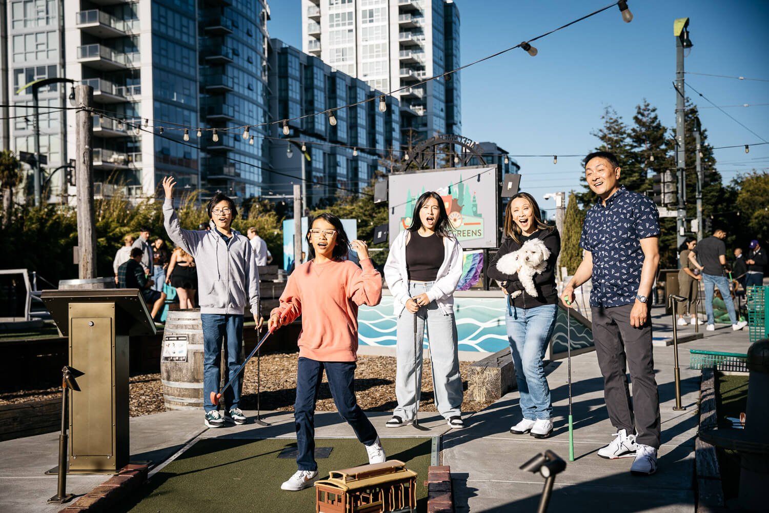 Family playing mini golf at Stagecoach Greens and laughing.