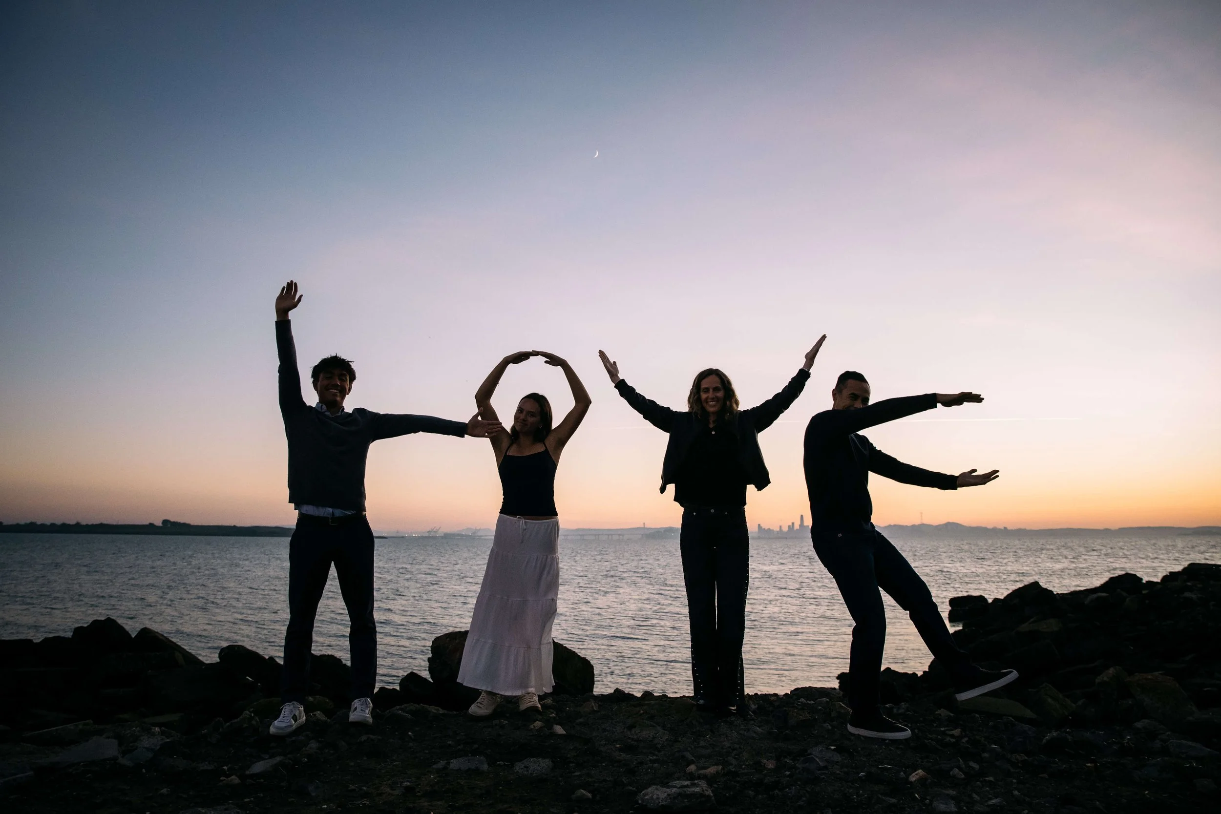 Family silhouette spelling the word LOVE against a sunset, shot at Albany Bulb during a family photo shoot.