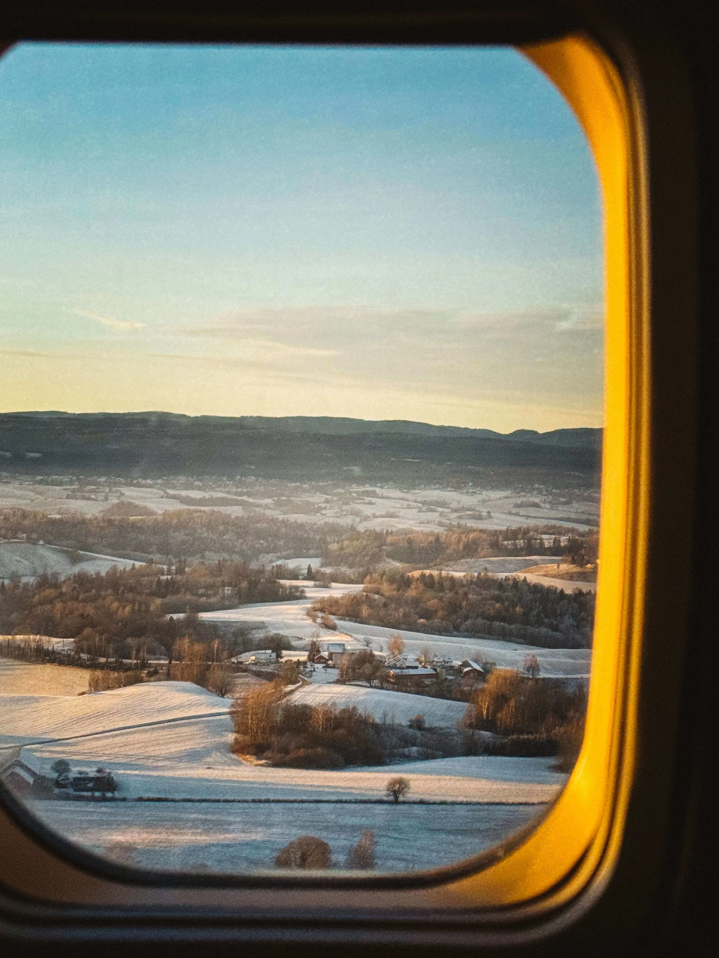 Snowy landscape in sunrise light, taken from an airplane window.