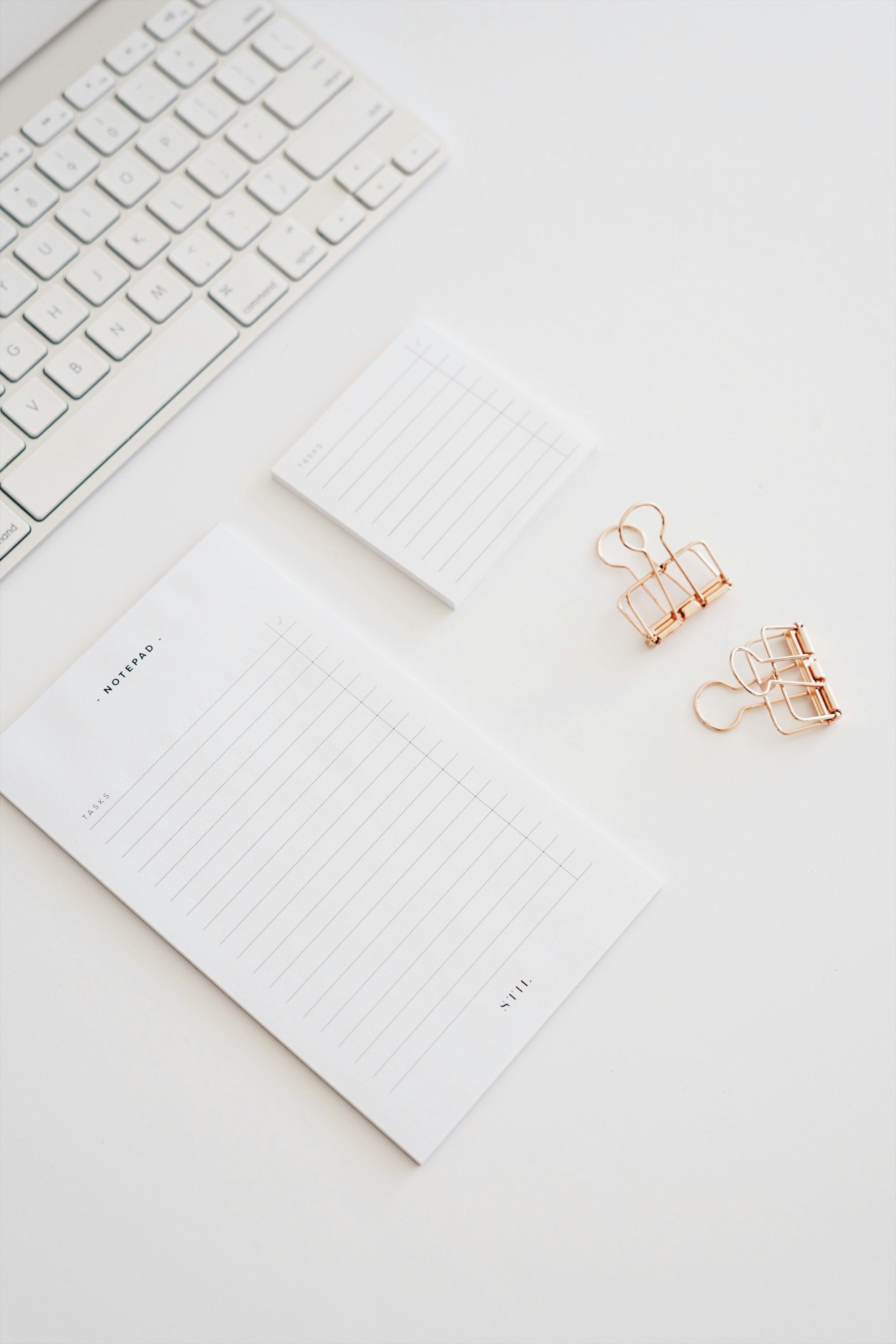 Notepads, clips, keyboard on desk.