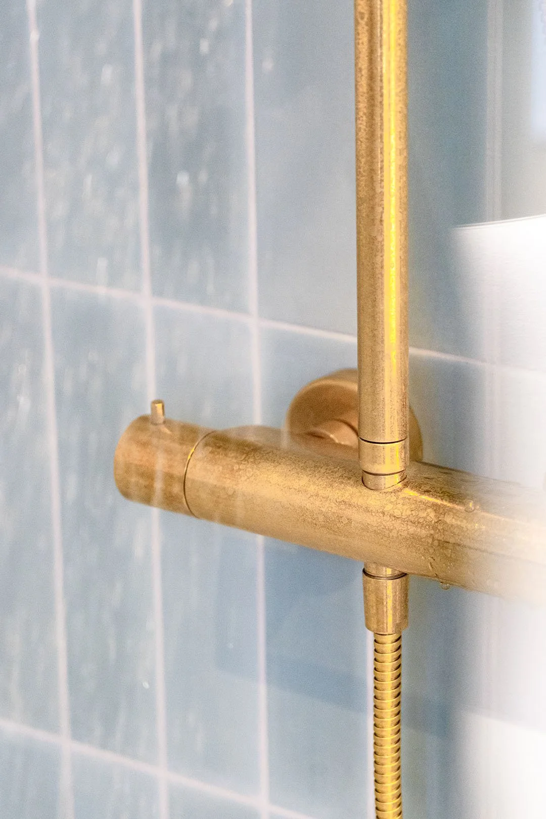 Messing bruser på væg med blå stav/sildebensfliser.