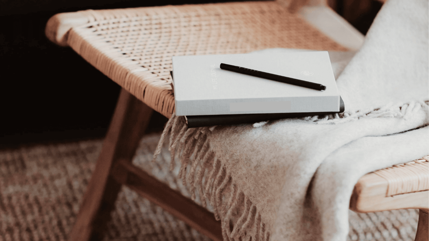Closed notebook with a pen on a blanket, representing a moment of reflection and inner work