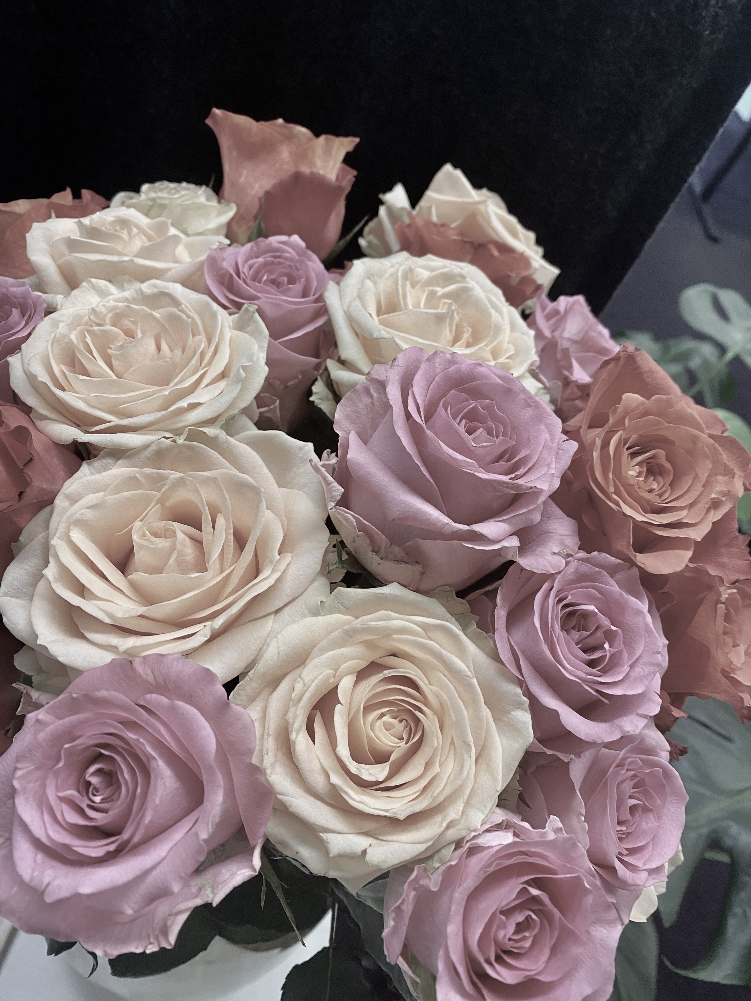 Bouquet of roses in shades of pink, purple, and cream.