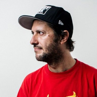 Profile of a man wearing a black baseball cap and a red T-shirt, looking to the side.