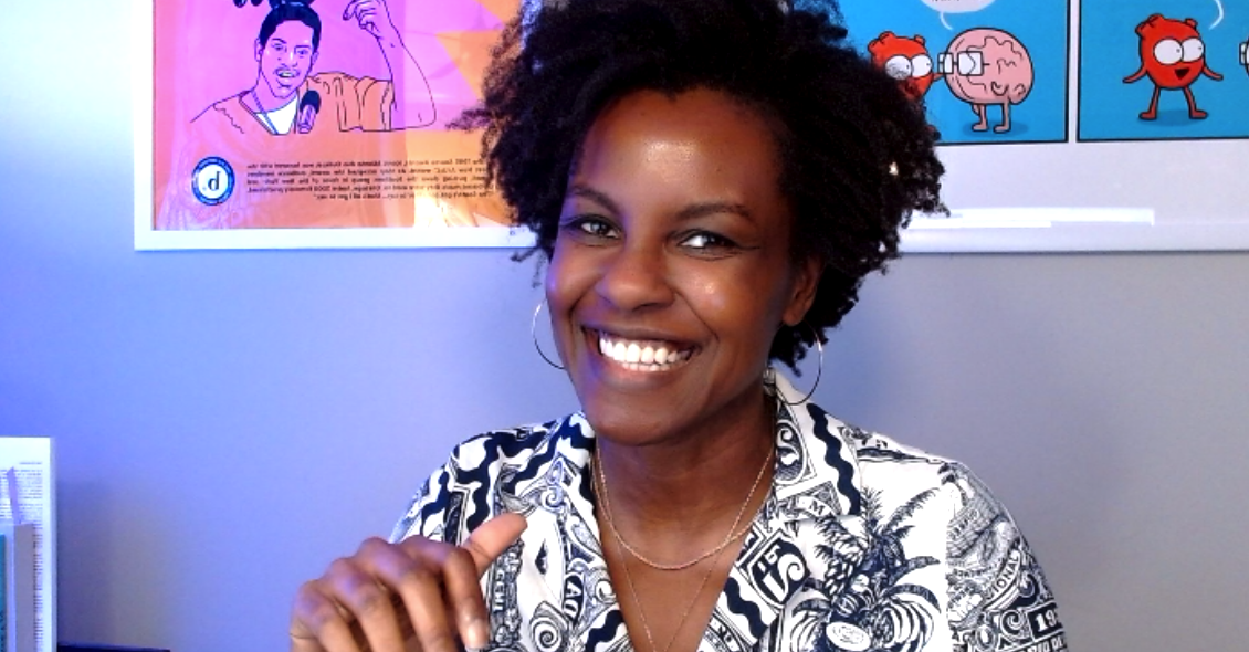 Photo of Sheyra sitting at her desk in front of a web cam