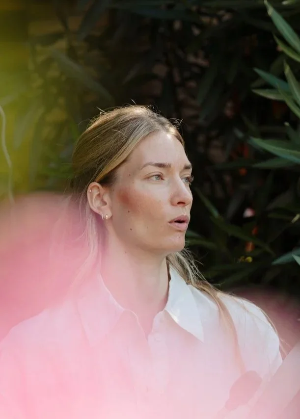 Black and white close-up of a woman's face with mouth slightly open; outdoors in a natural setting.
