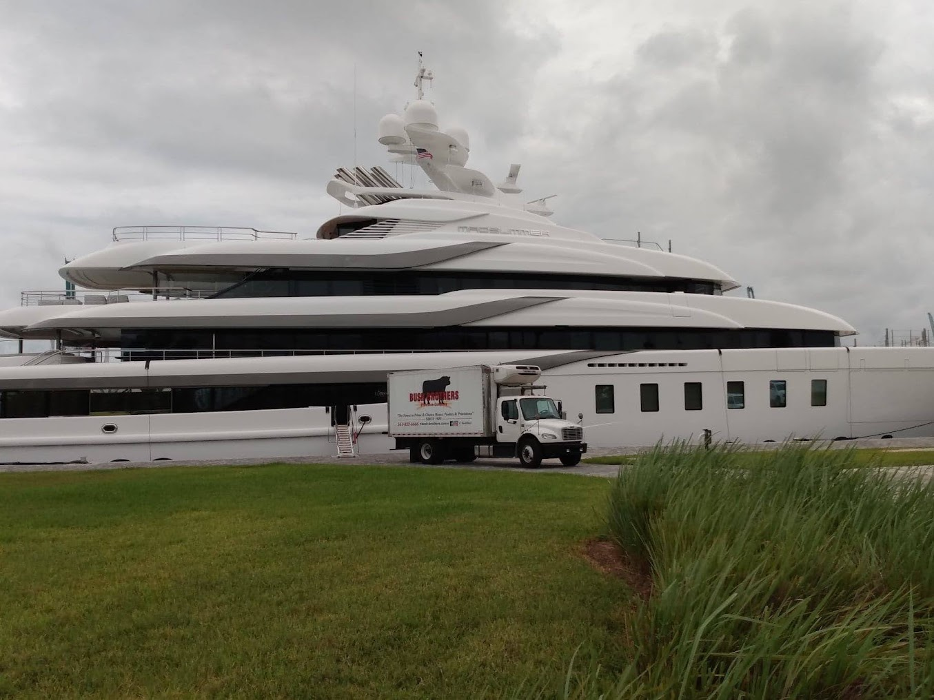 Bush Brothers refrigerated truck parked dockside beside a superyacht