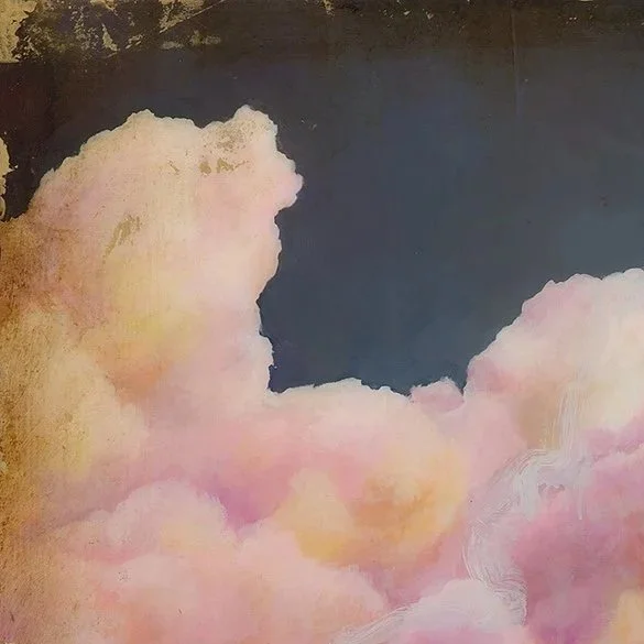 Close-up of a painted sky with large fluffy pink and yellow clouds and a dark blue background.